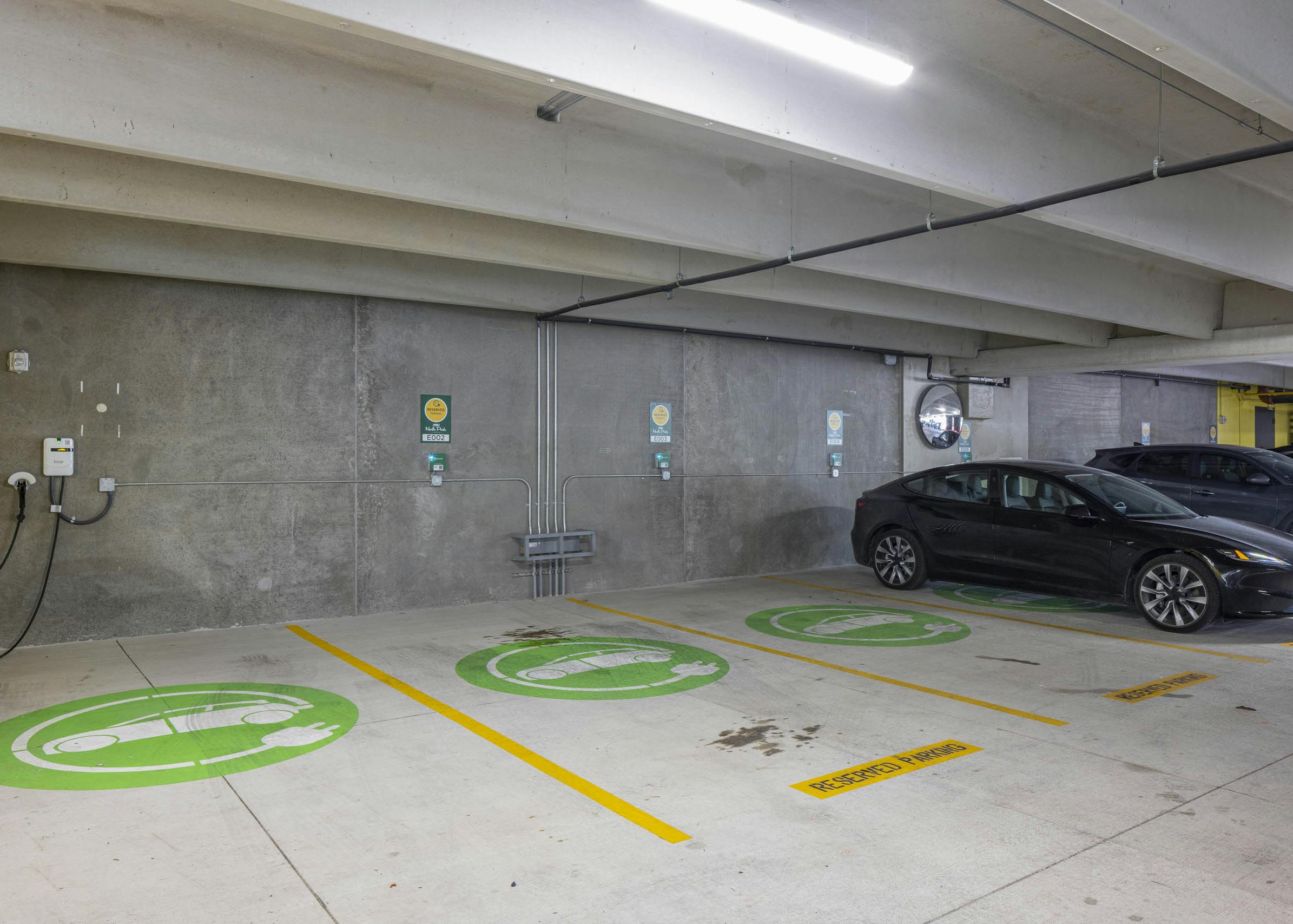 EV charging area at AMLI North Park apartment community parking garage showing three reservable electric charging stations
