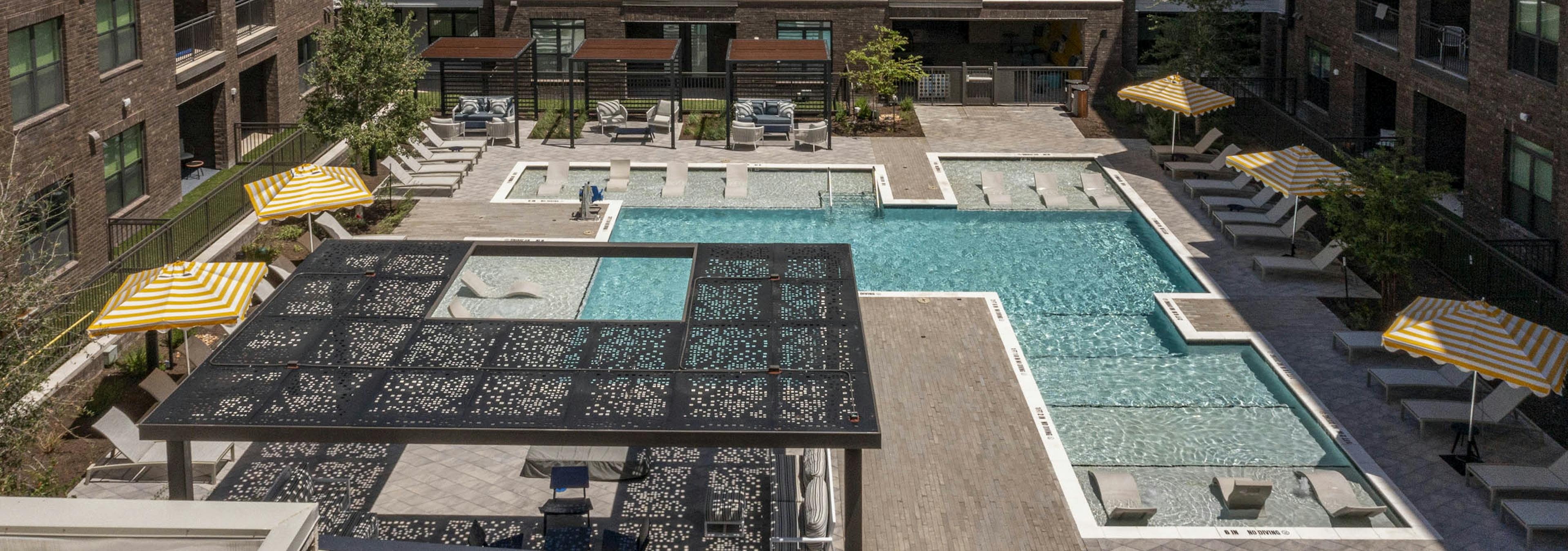 Courtyard at AMLI North Park with swimming pool lounge chairs umbrellas shaded seating and apartment buildings with balconies