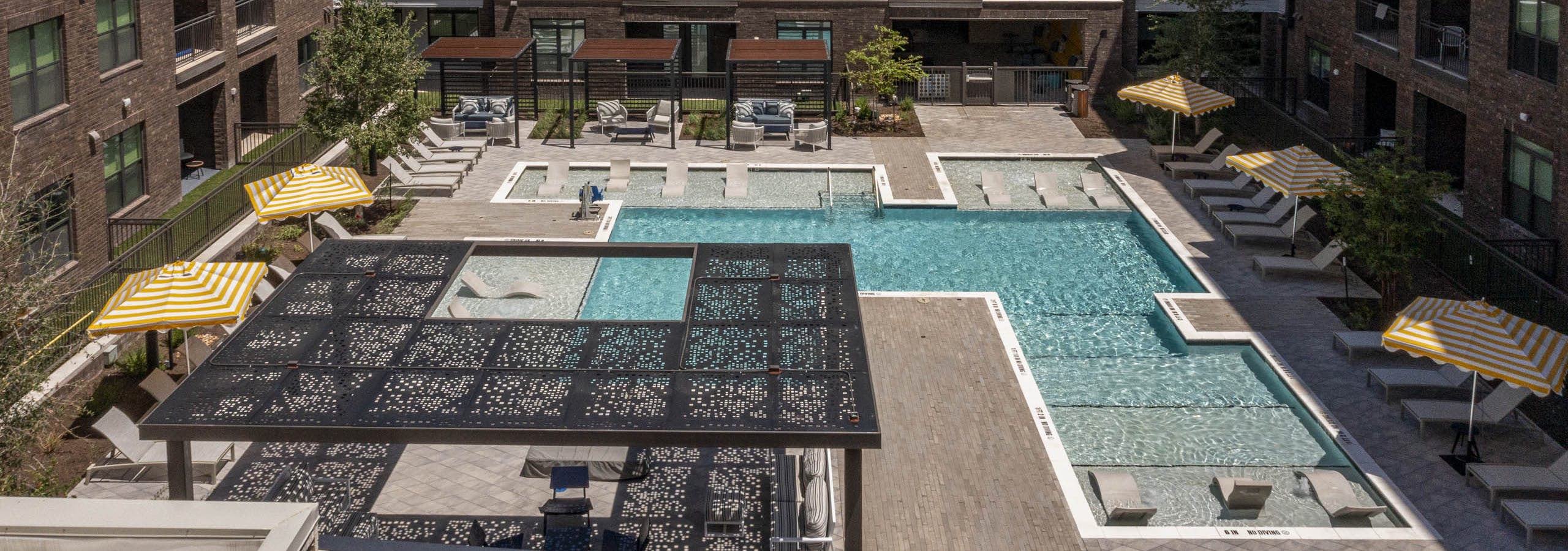 Courtyard at AMLI North Park with swimming pool lounge chairs umbrellas shaded seating and apartment buildings with balconies