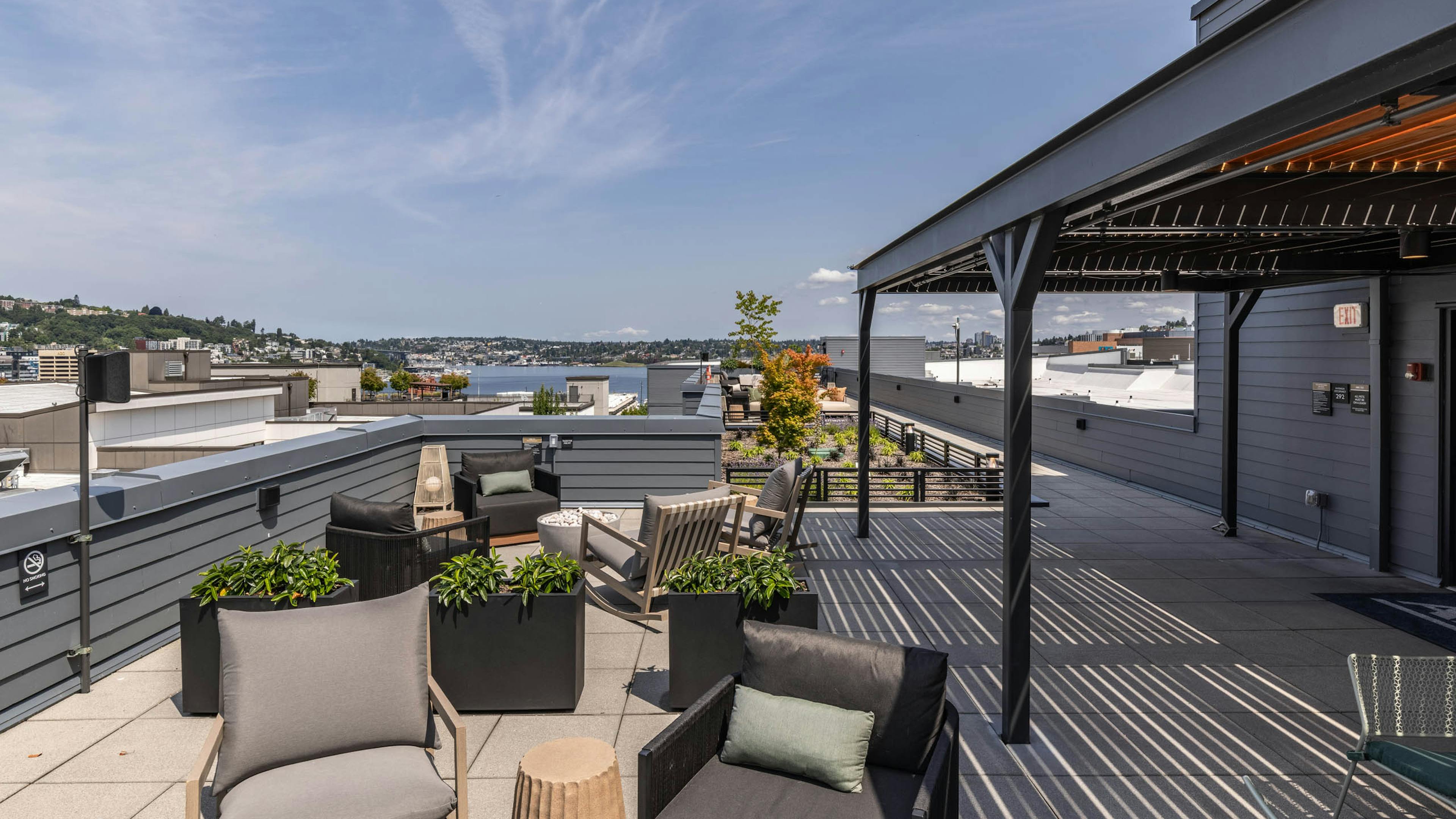 Rooftop seating at AMLI 535 apartments with planters, gray chairs, and sweeping views of Lake Union and the surrounding hills.