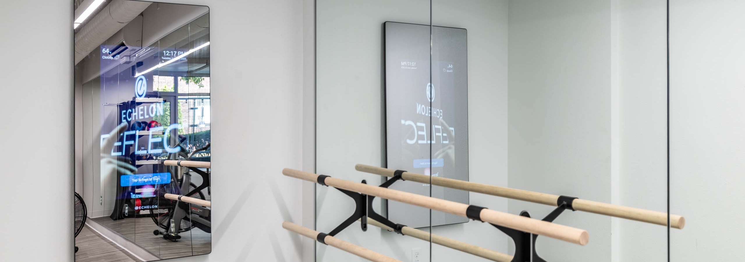 Workout studio at AMLI 535 apartments with ballet barre, mirrored walls, and interactive Echelon fitness mirror on white wall.