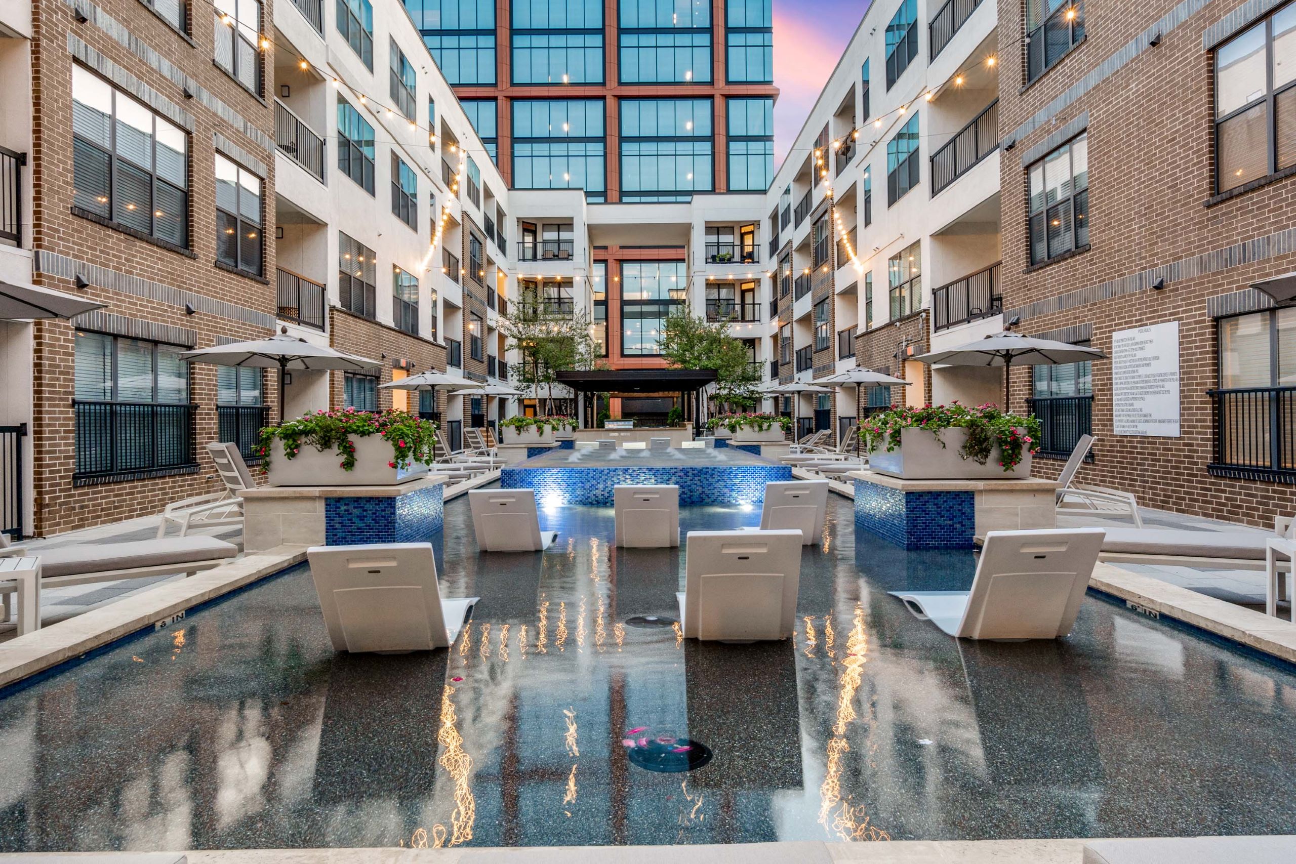AMLI Quadrangle view of back of pool loungers in cooling spa facing The Quad office building surrounded by apartments.