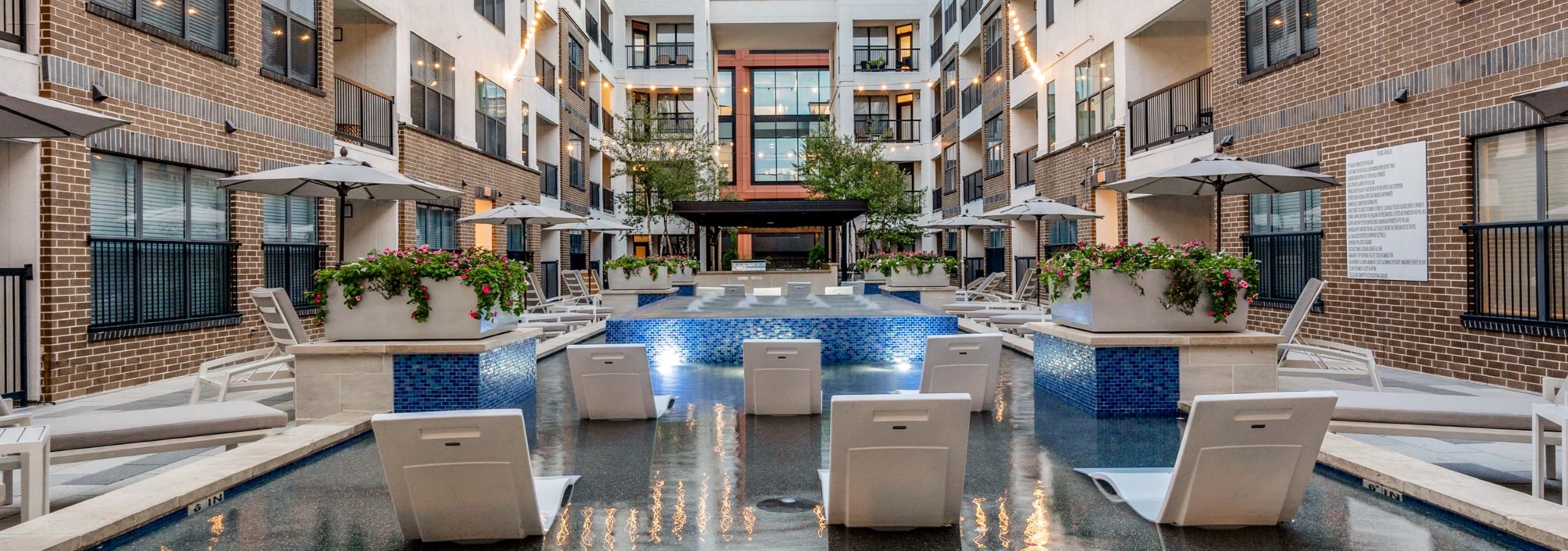 AMLI Quadrangle view of back of pool loungers in cooling spa facing The Quad office building surrounded by apartments.