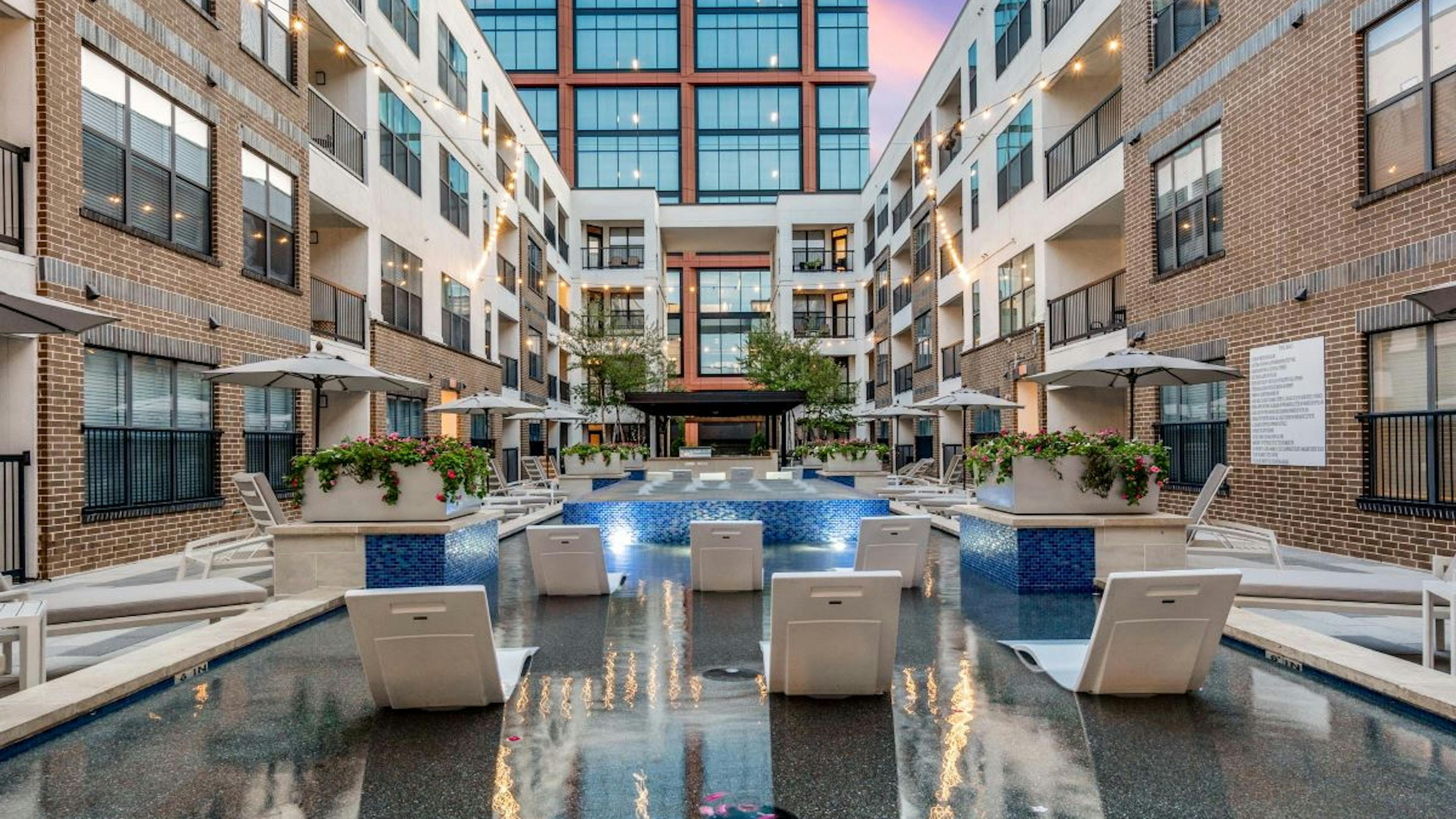 AMLI Quadrangle view of back of pool loungers in cooling spa facing The Quad office building surrounded by apartments.