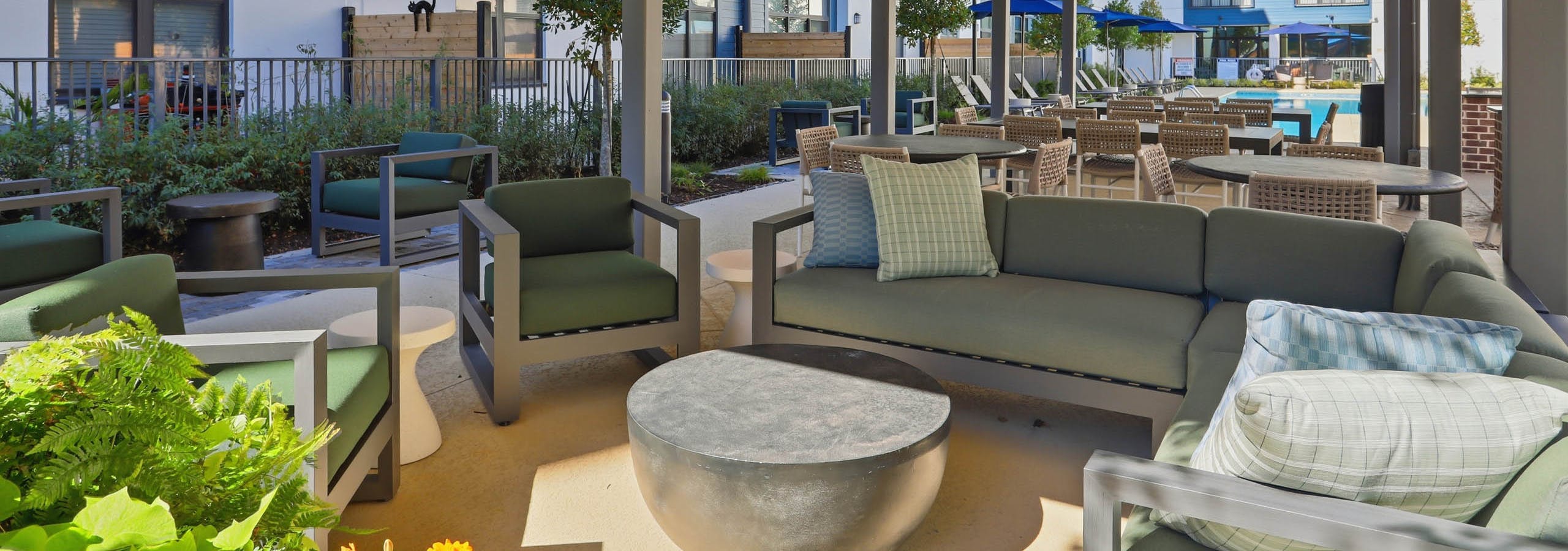 Covered lounge seating and dining area by the pool at AMLI Old 4th Ward