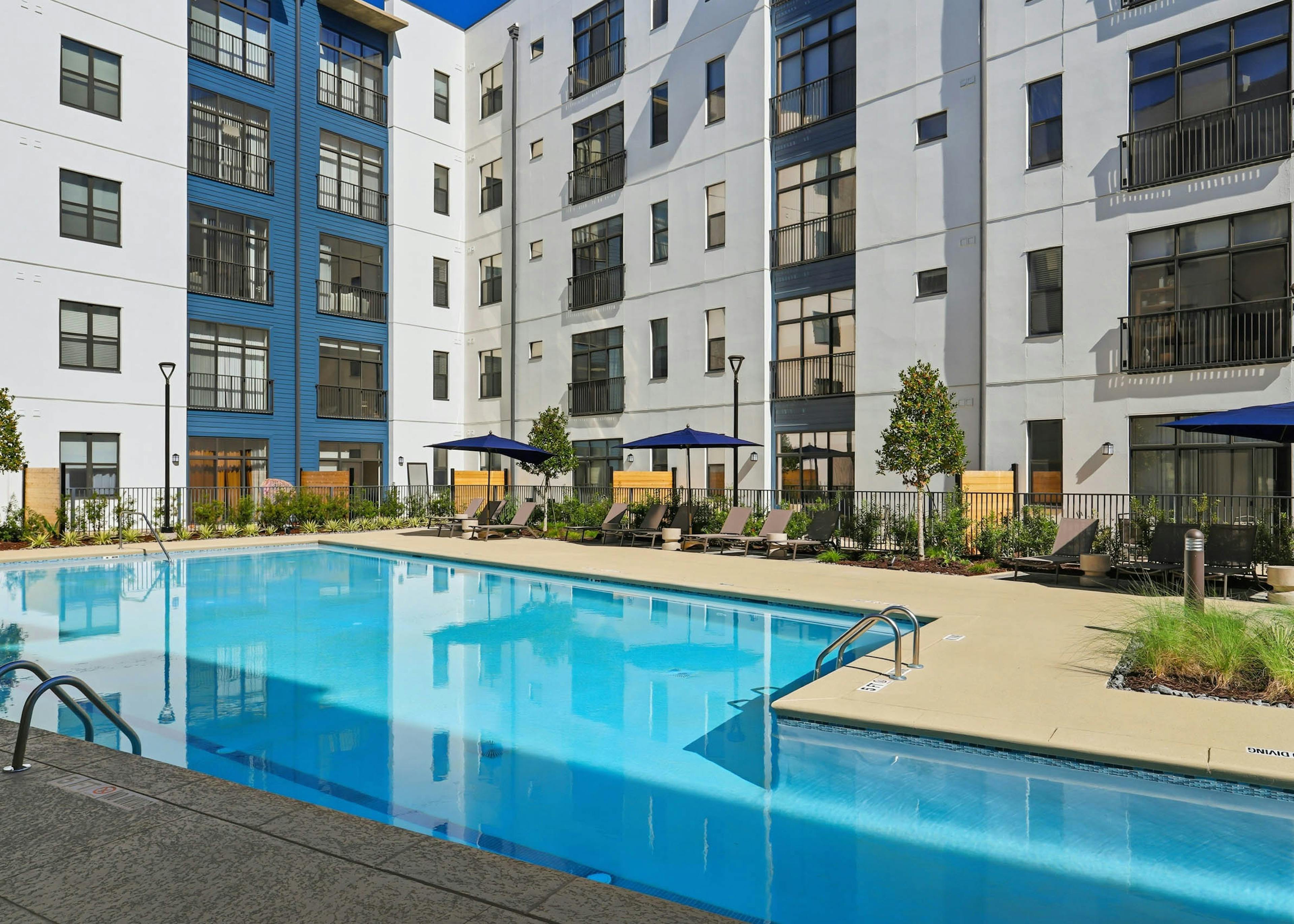 Pool deck with lounge chairs and umbrellas at AMLI Old 4th Ward.