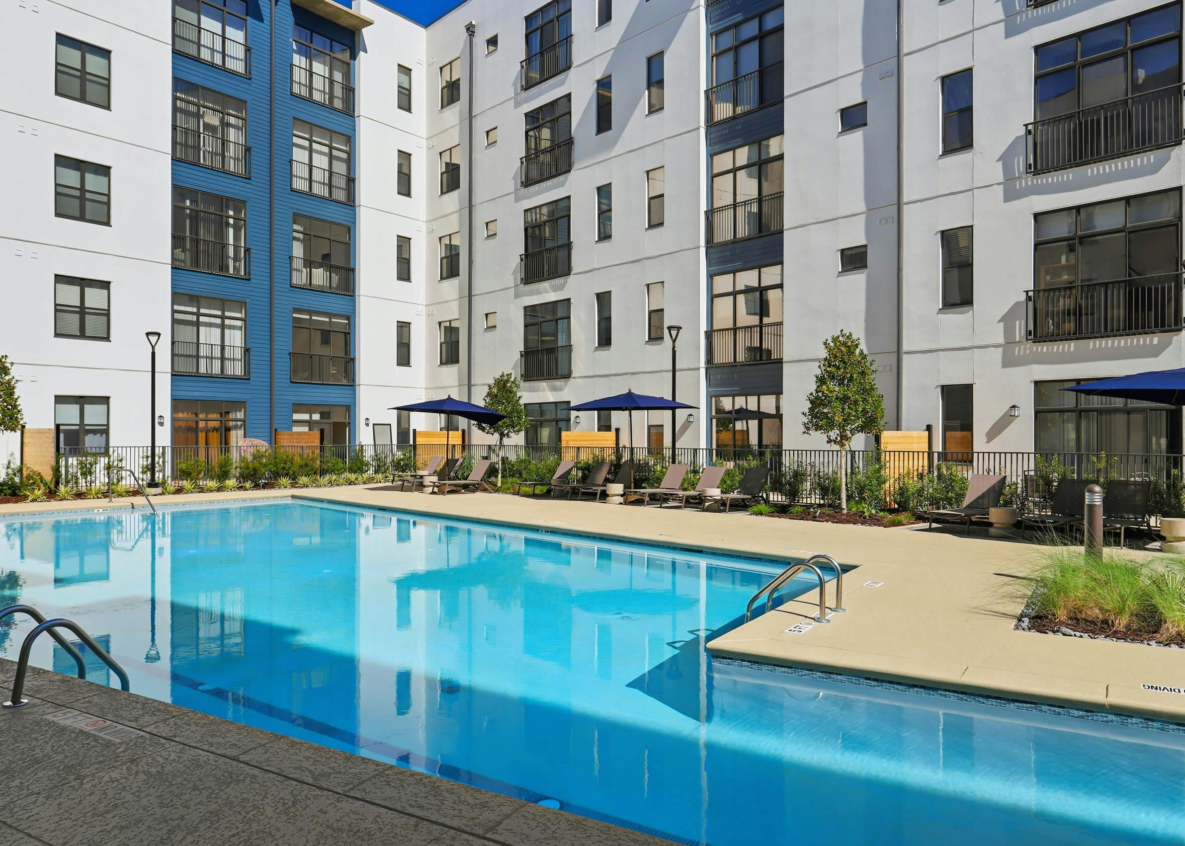 Pool deck with lounge chairs and umbrellas at AMLI Old 4th Ward.