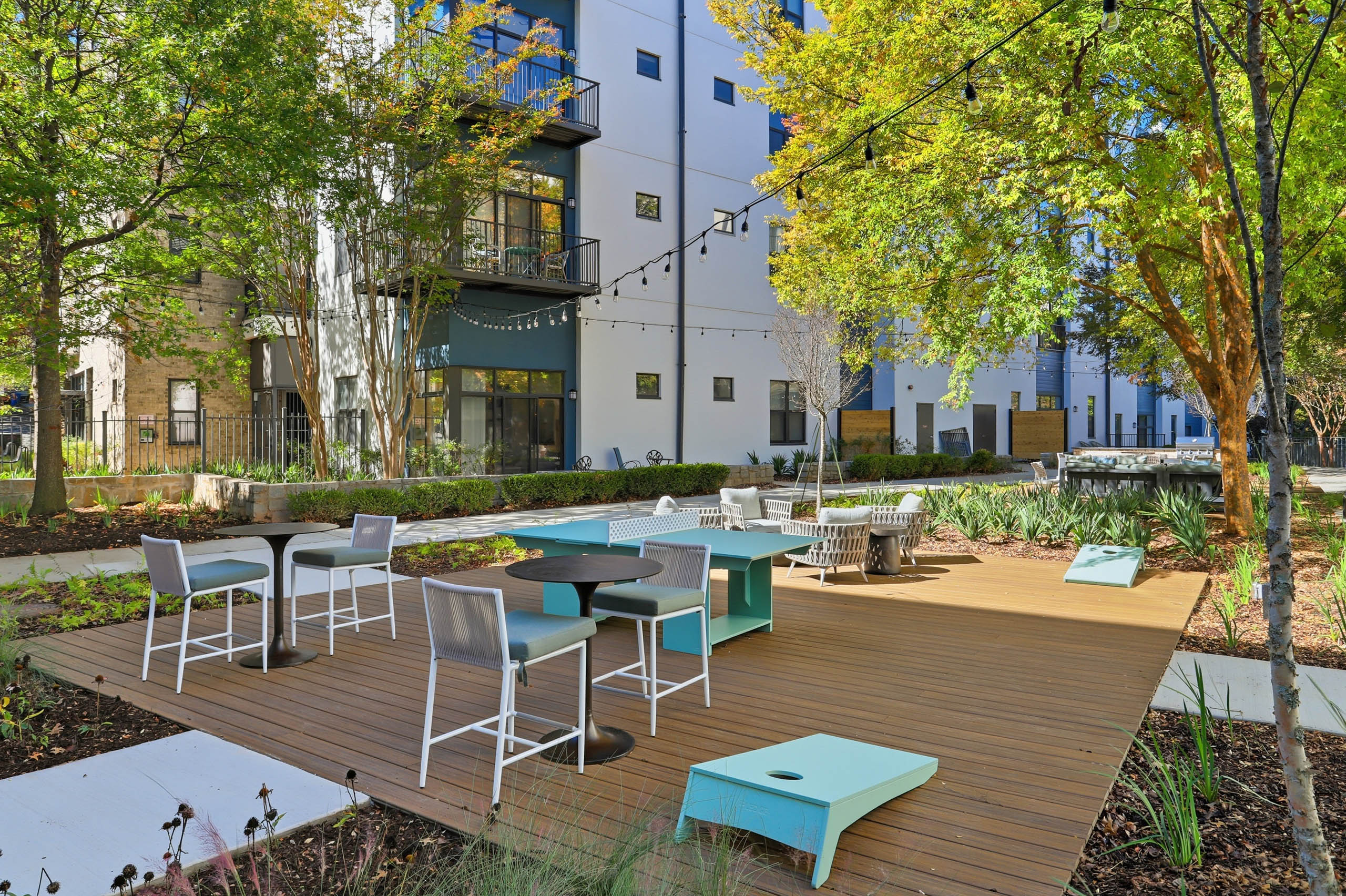 Outdoor lounge area at AMLI Old 4th Ward with cornhole and table tennis