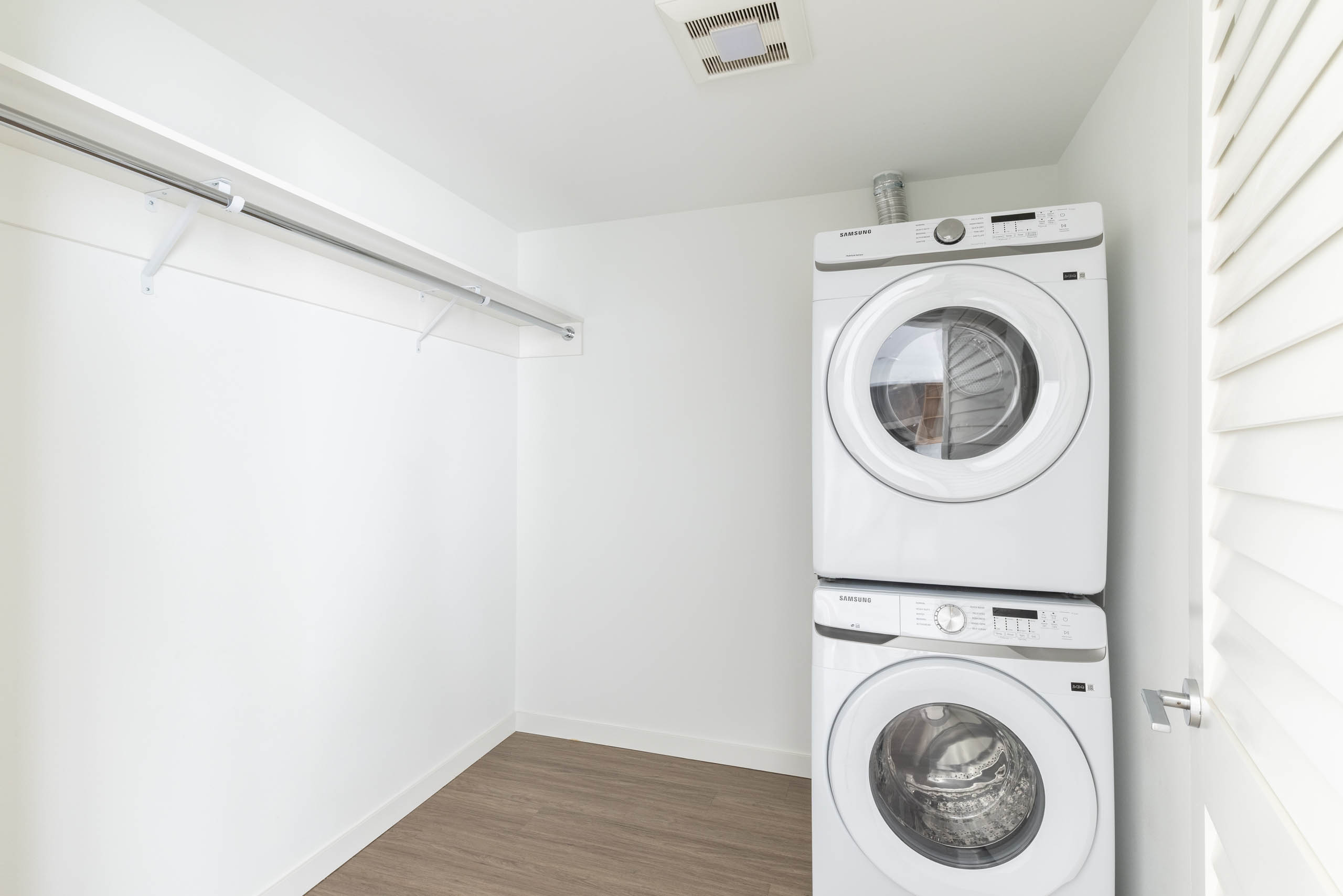 Interior view of laundry area with stacked washer dryer and adjacent walk-in closet space at AMLI Redmond Way apartments.