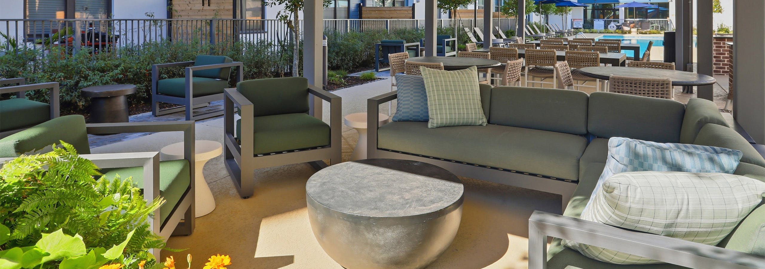 Covered lounge seating and dining area by the pool at AMLI Old 4th Ward