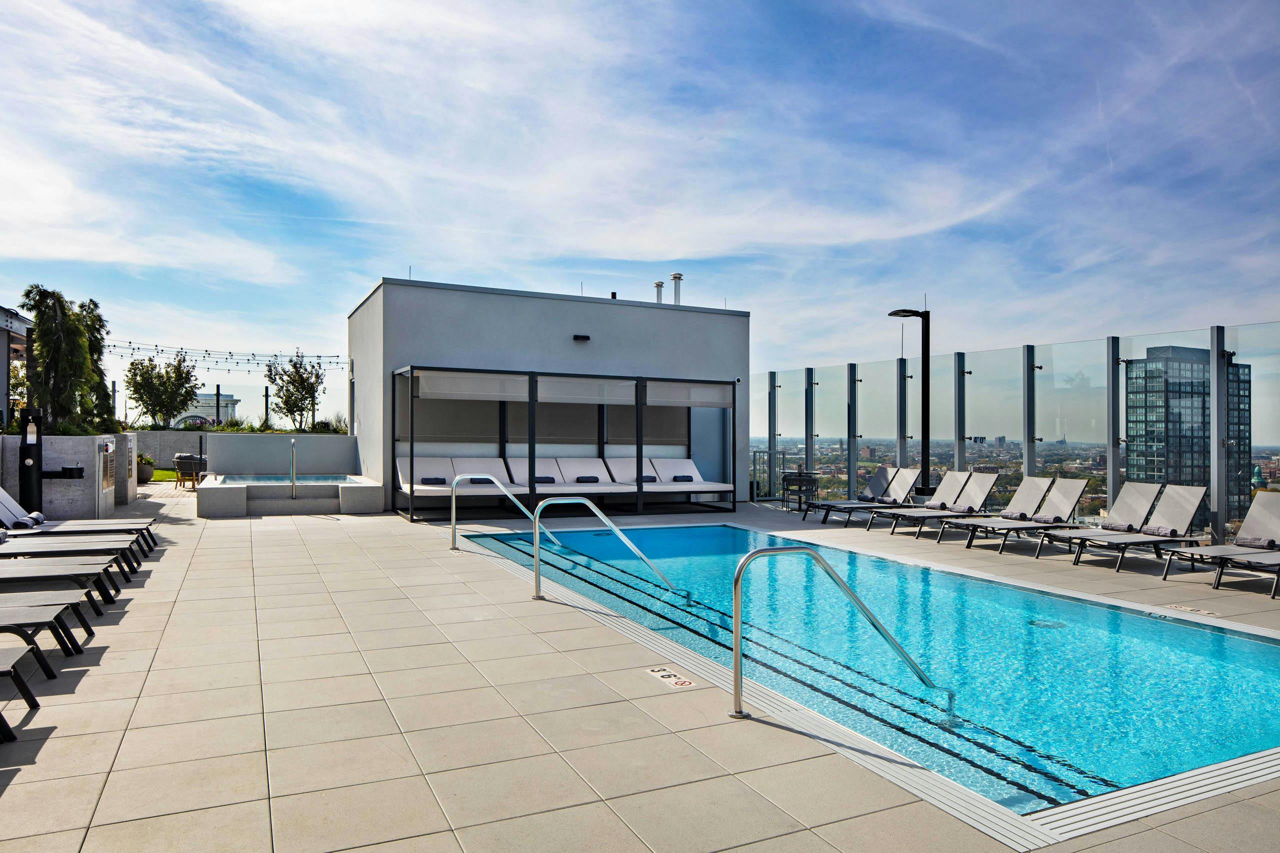Luxurious rooftop pool and spa at AMLI West Loop apartment building with grey lounge chairs and cabana.