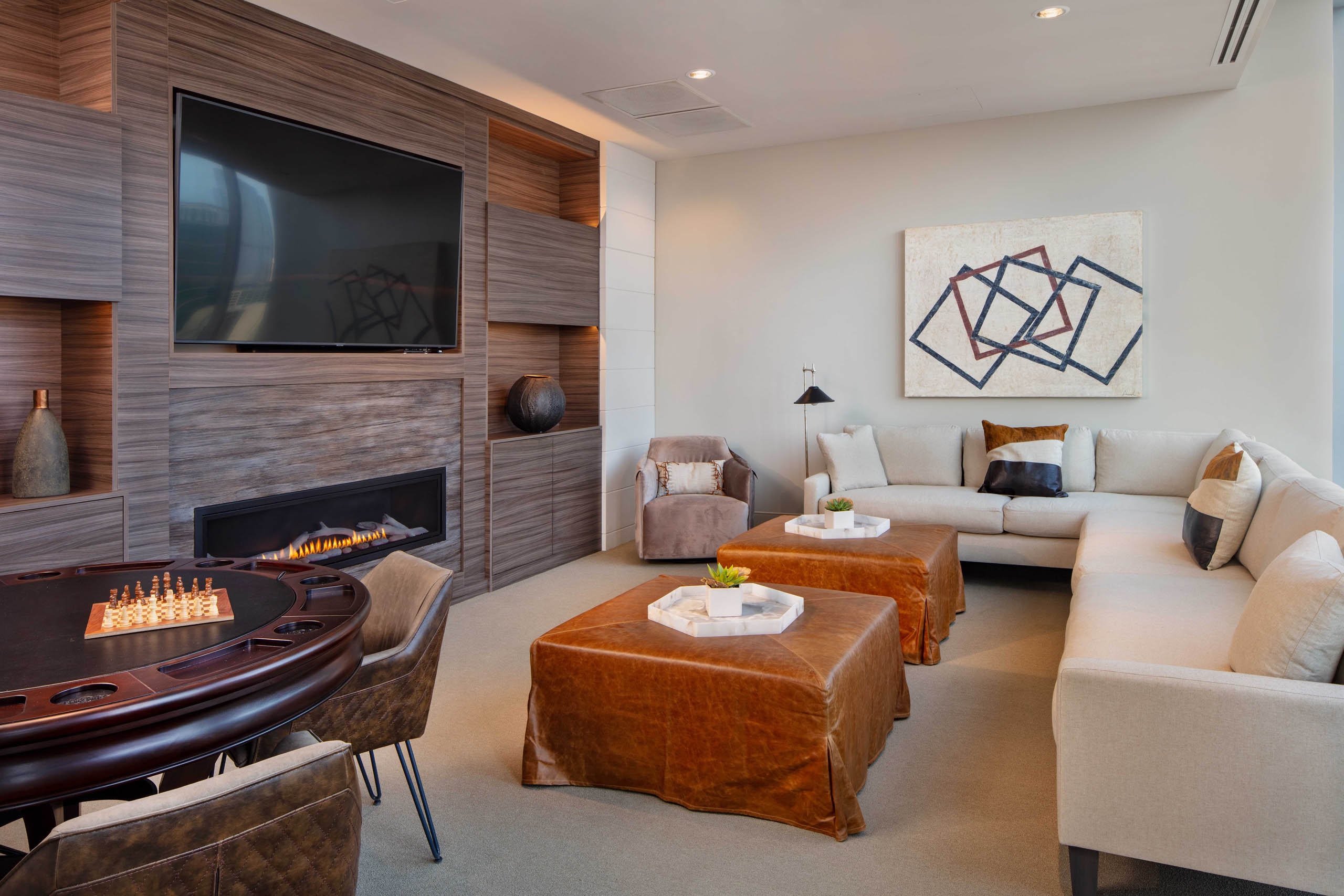 AMLI West Loop Media Room featuring a white couch and leather ottomans with a poker table and a modern fireplace