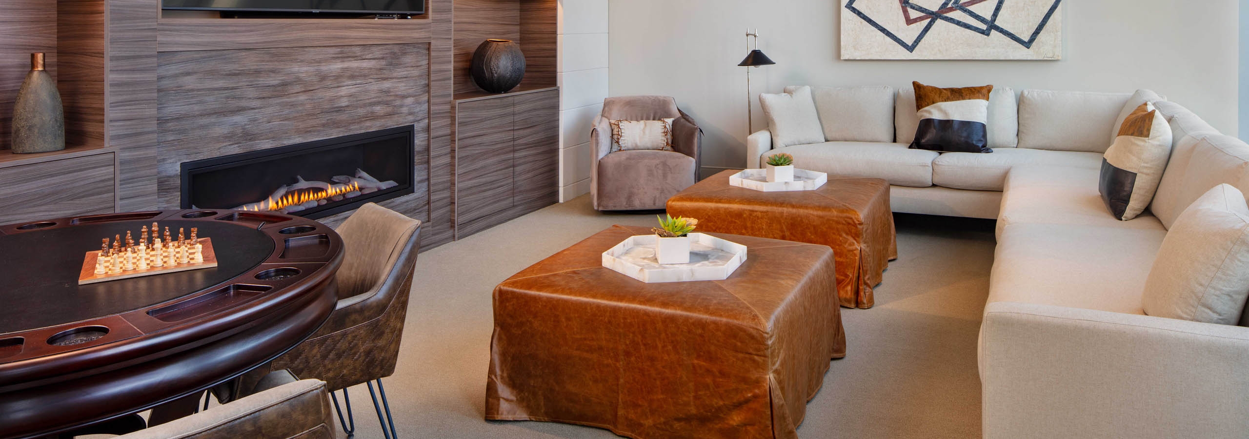 AMLI West Loop Media Room featuring a white couch and leather ottomans with a poker table and a modern fireplace