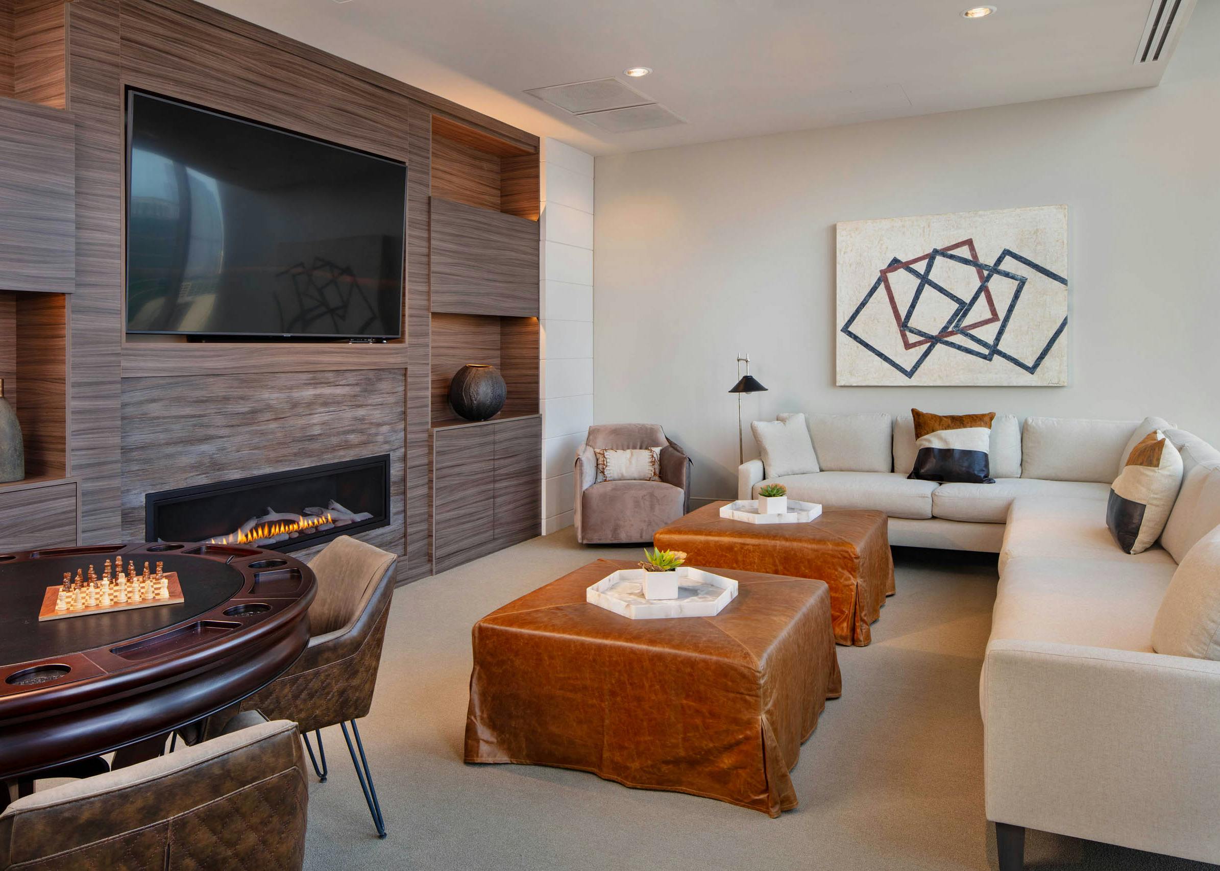 AMLI West Loop Media Room featuring a white couch and leather ottomans with a poker table and a modern fireplace