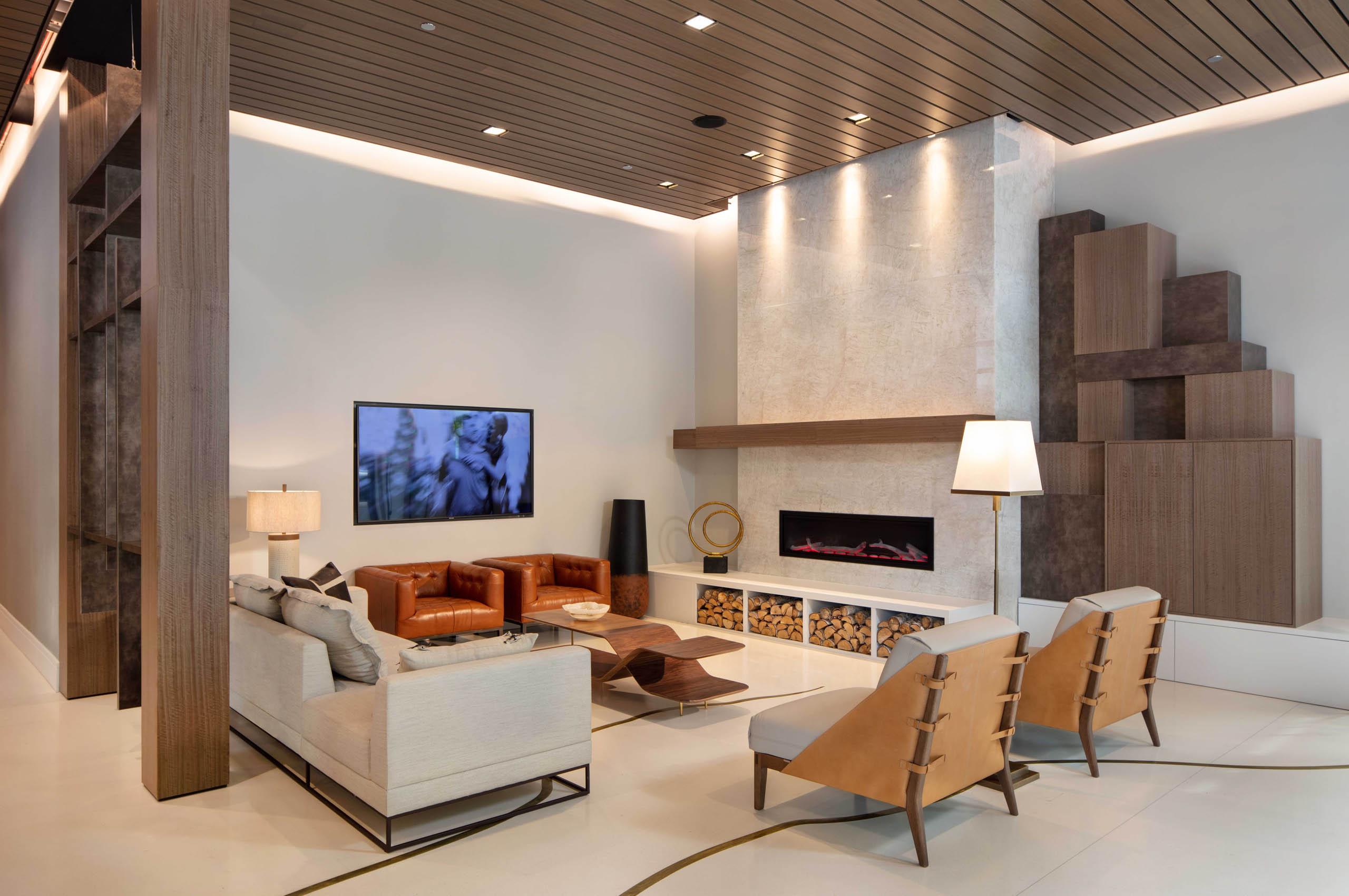 AMLI West Loop lobby with comfortable seating and a mounted TV featuring a fireplace and a wood slat ceiling.