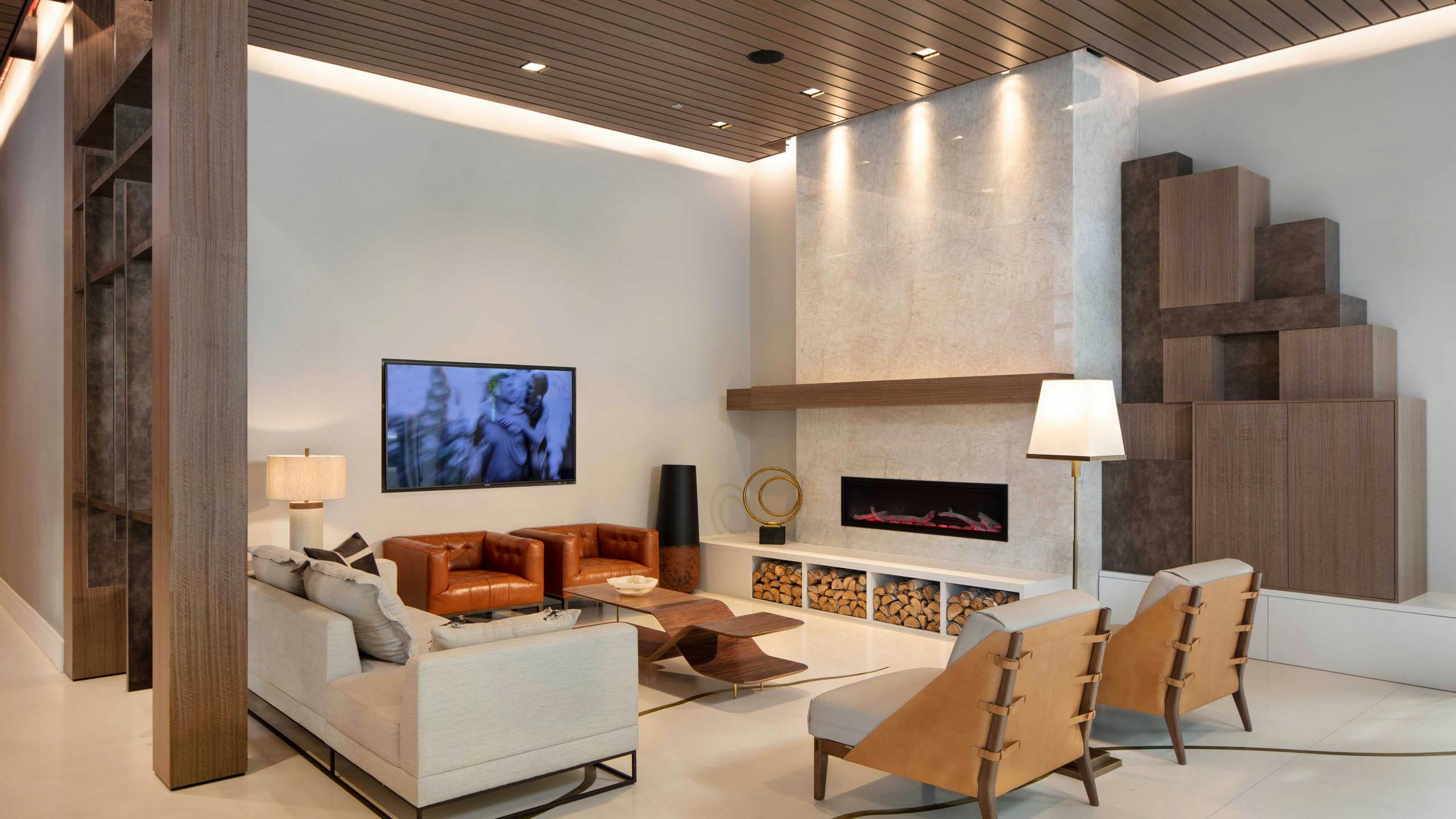 AMLI West Loop lobby with comfortable seating and a mounted TV featuring a fireplace and a wood slat ceiling.
