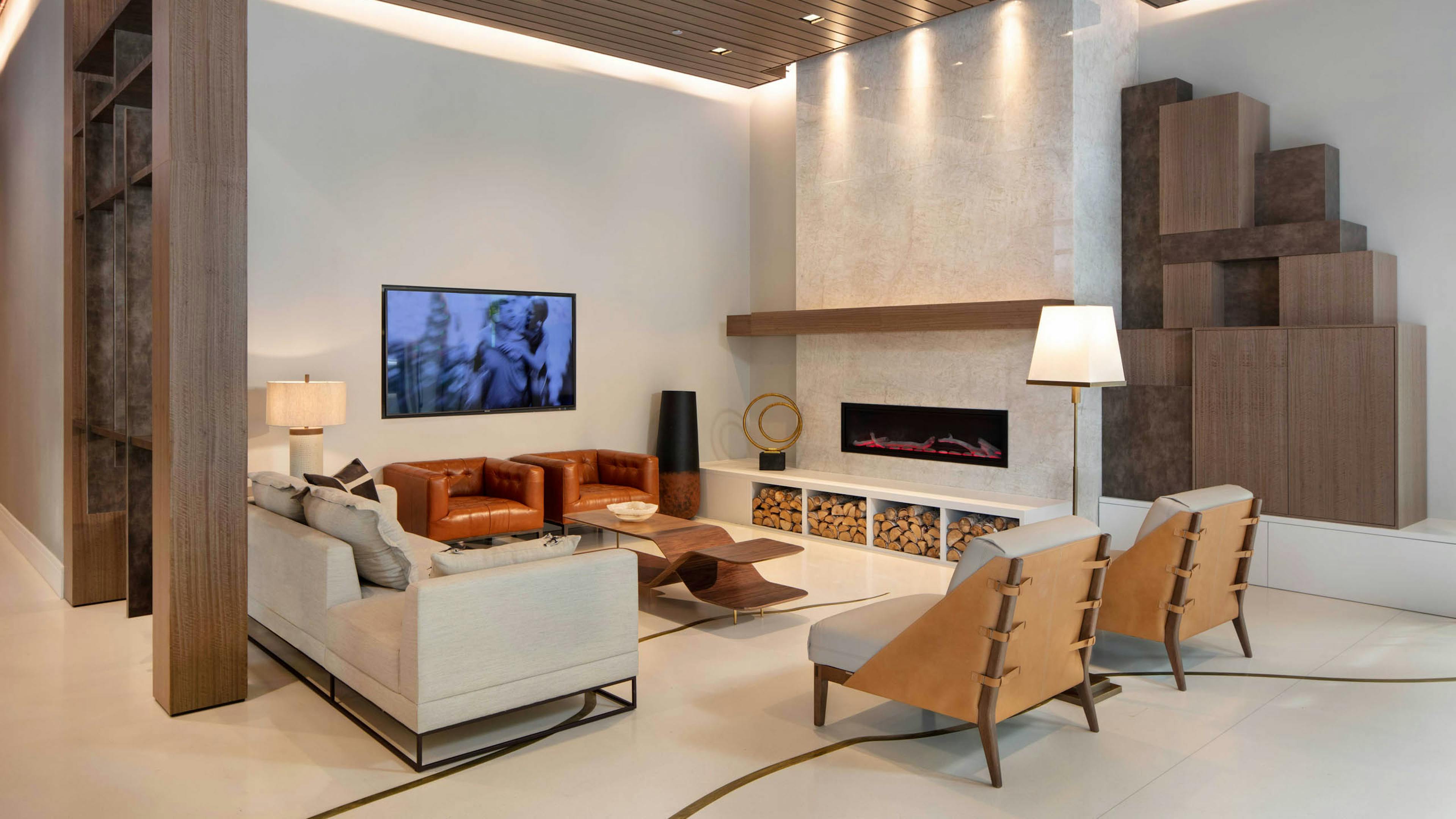 AMLI West Loop lobby with comfortable seating and a mounted TV featuring a fireplace and a wood slat ceiling.