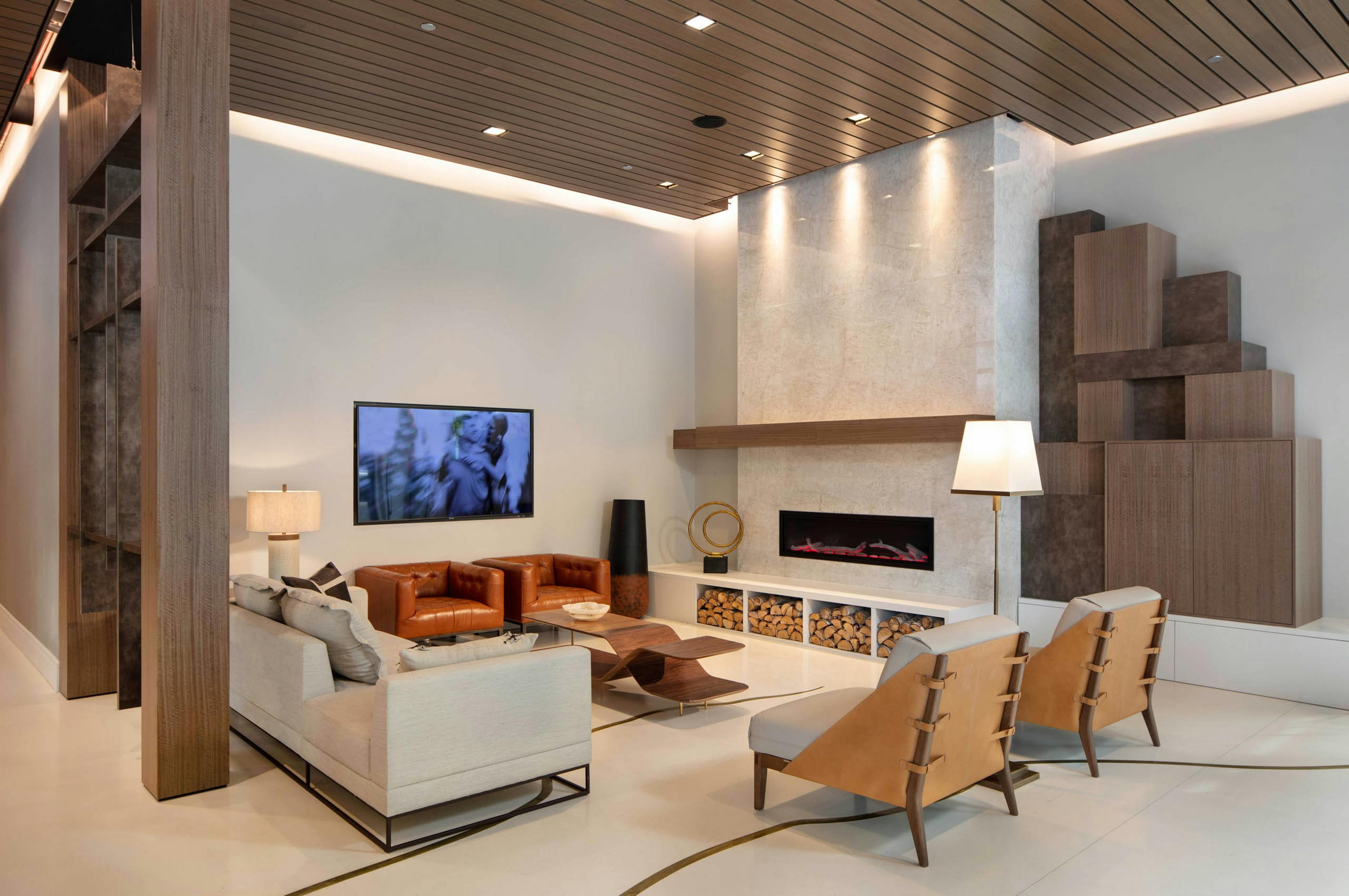 AMLI West Loop lobby with comfortable seating and a mounted TV featuring a fireplace and a wood slat ceiling.
