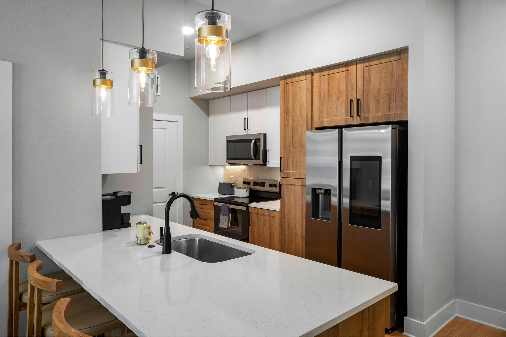 Interior shot of AMLI North Park kitchen with large island and two-toned cabinets
