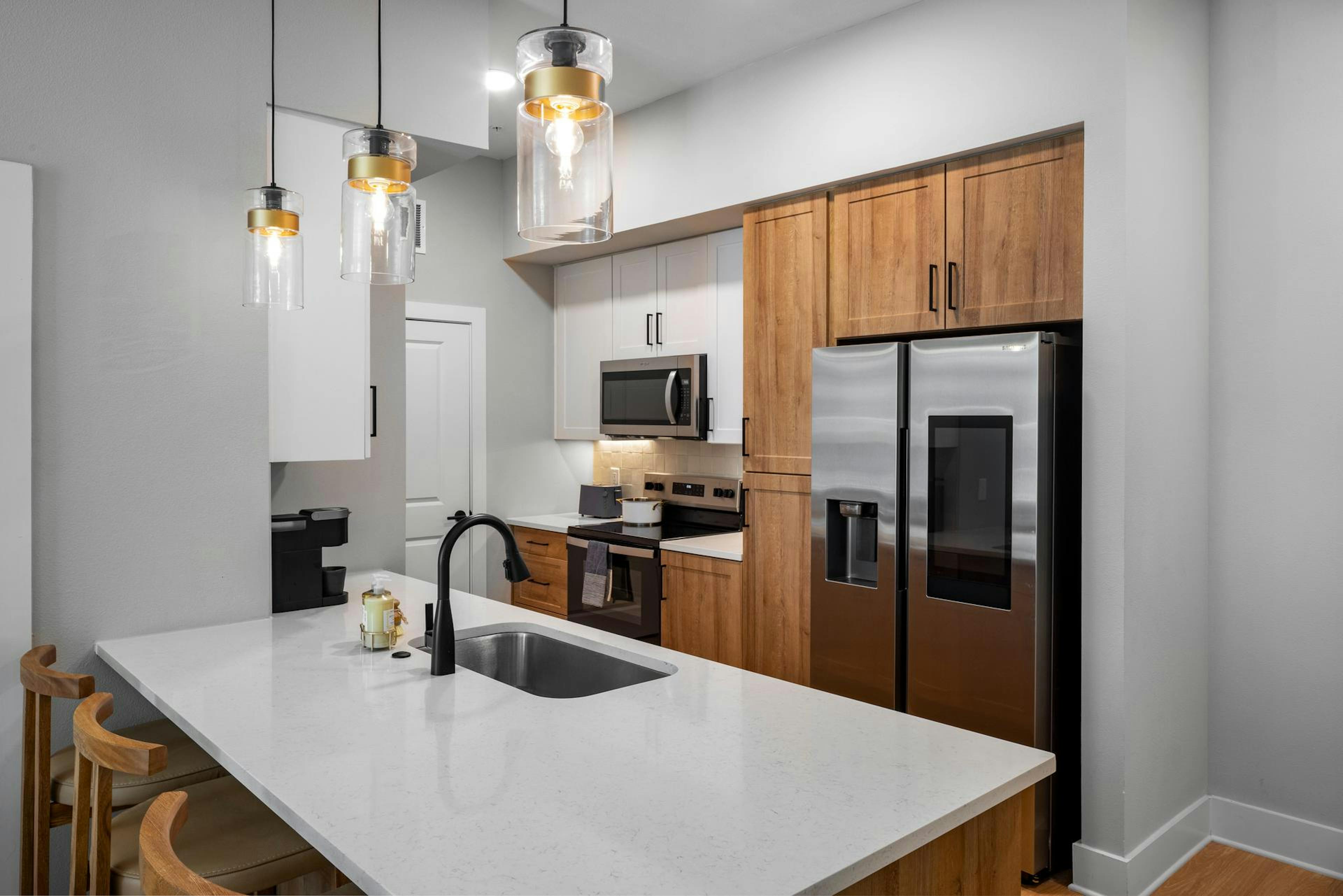 Interior shot of AMLI North Park kitchen with large island and two-toned cabinets