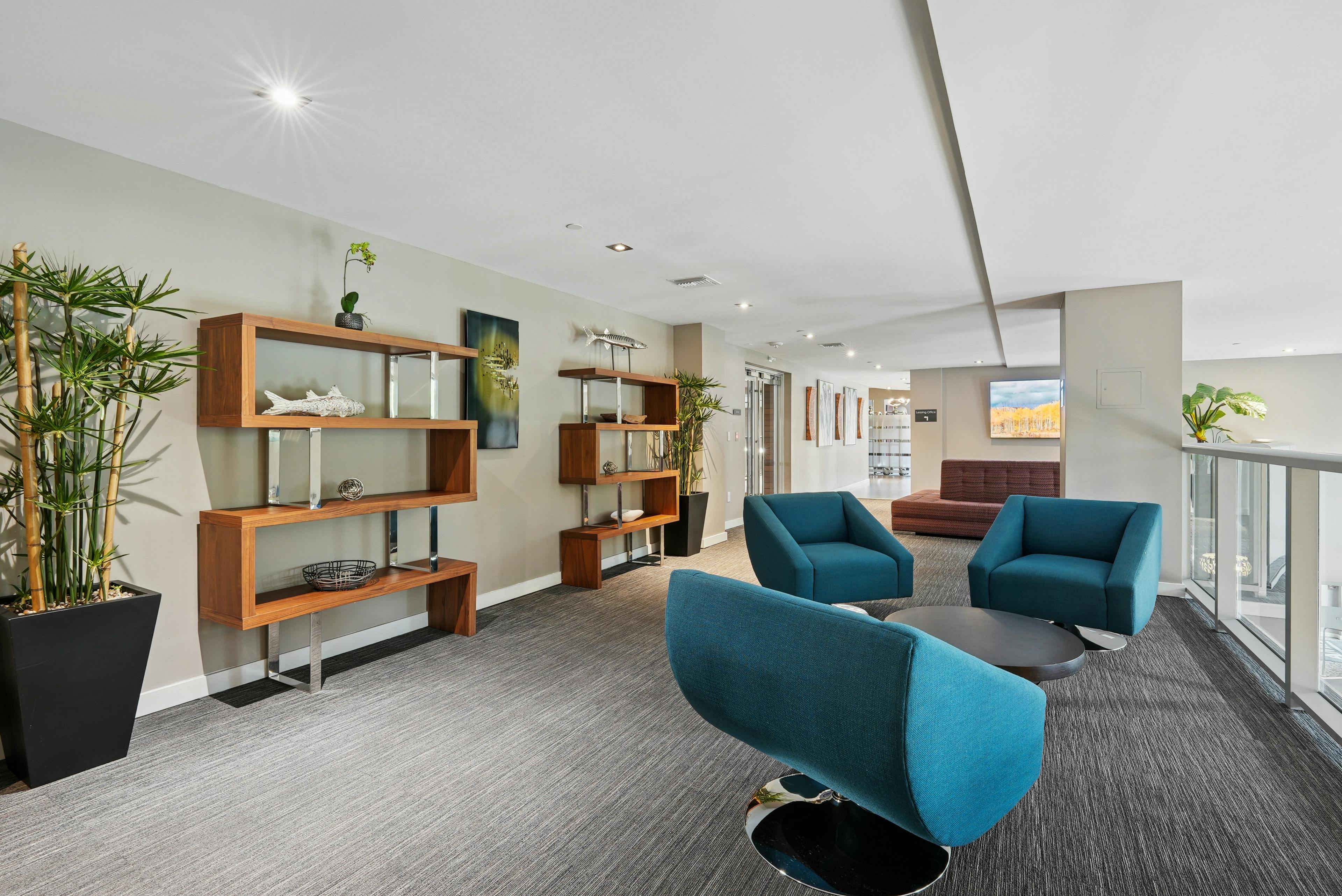 Resident lounge at AMLI Dadeland apartments with bamboo planters and wooden wall unit cabinetry showcasing fish sculptures