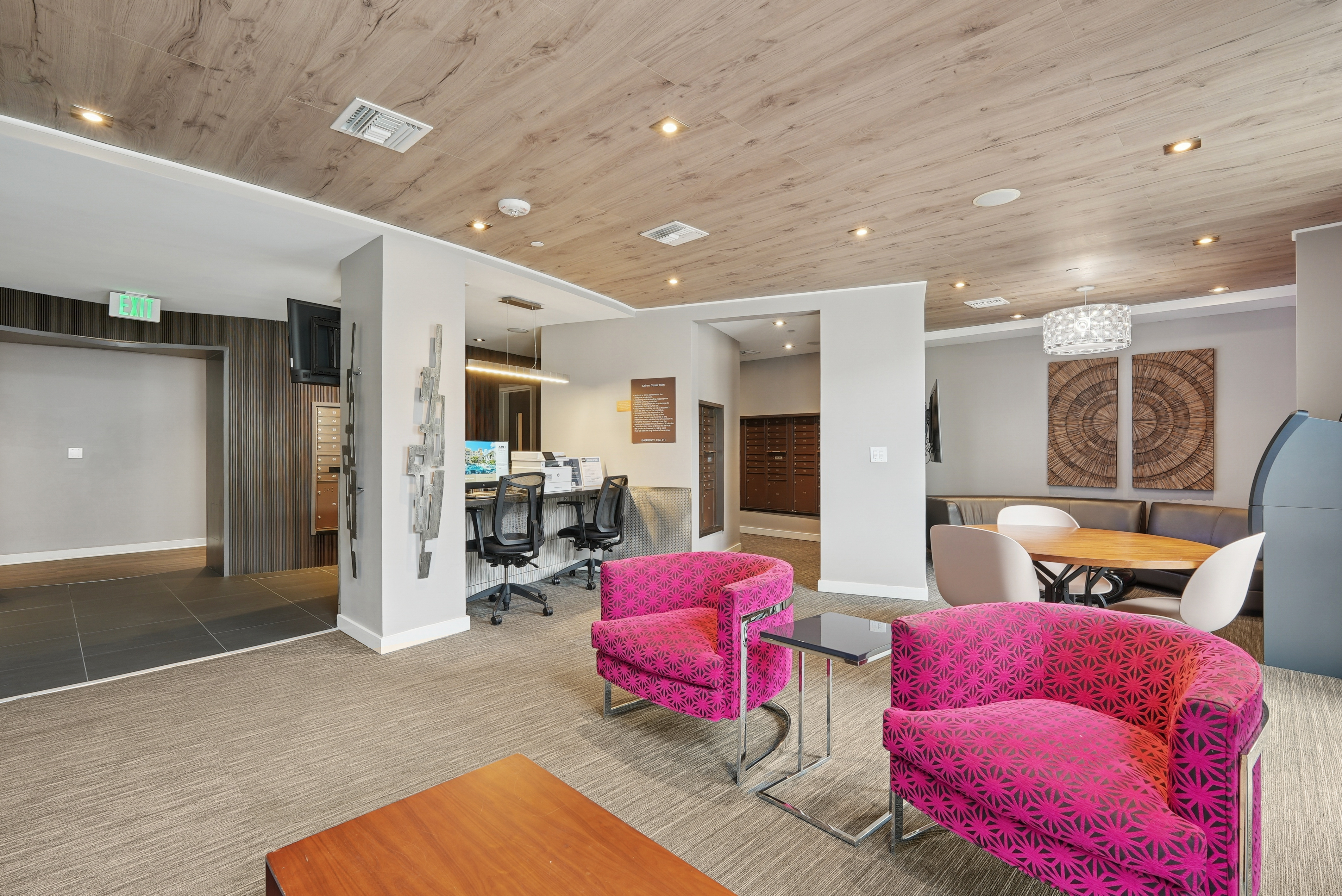 AMLI Dadeland apartments business center with a desktop computer and printer and multiple chairs and a view into the mailroom