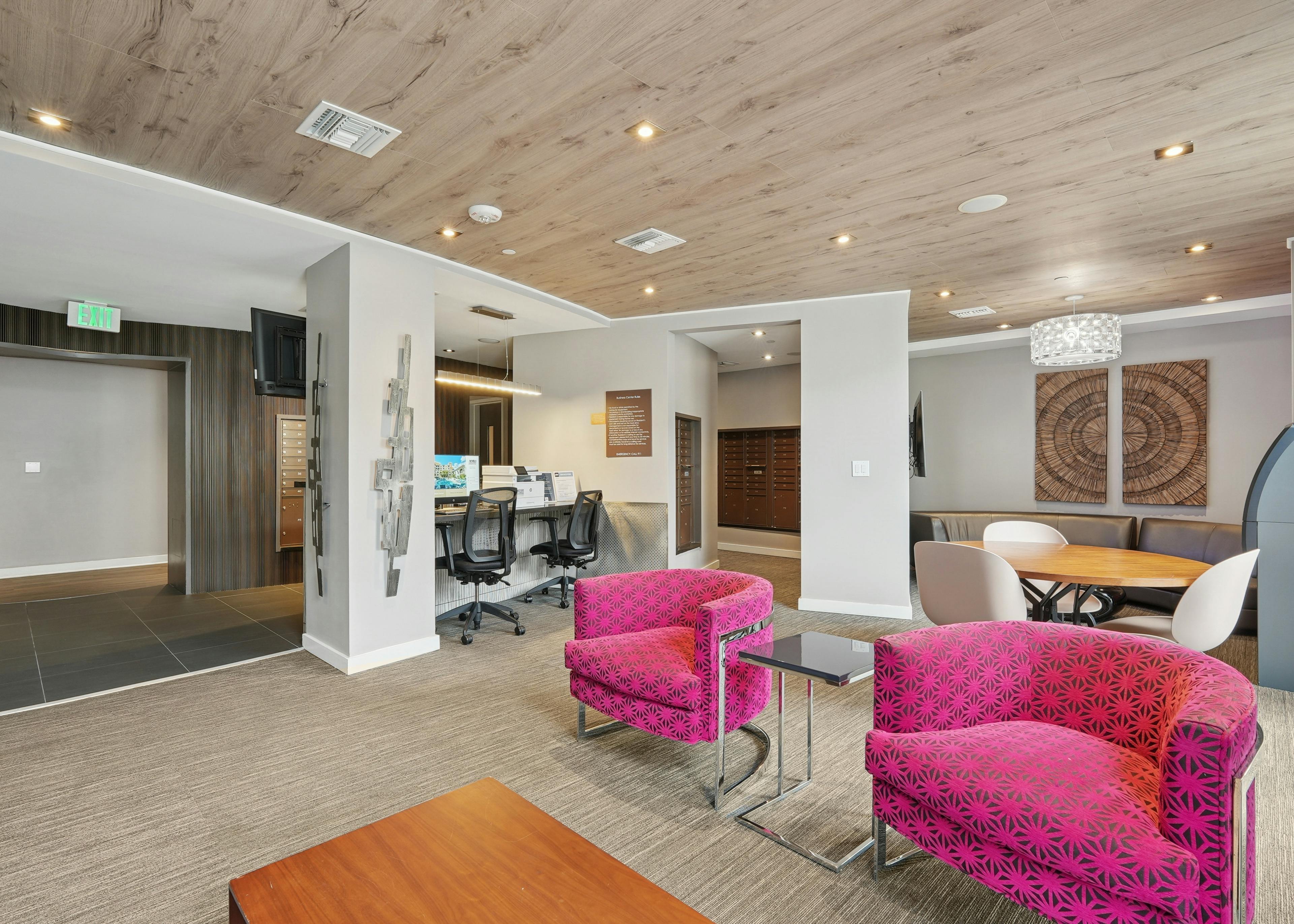 AMLI Dadeland apartments business center with a desktop computer and printer and multiple chairs and a view into the mailroom