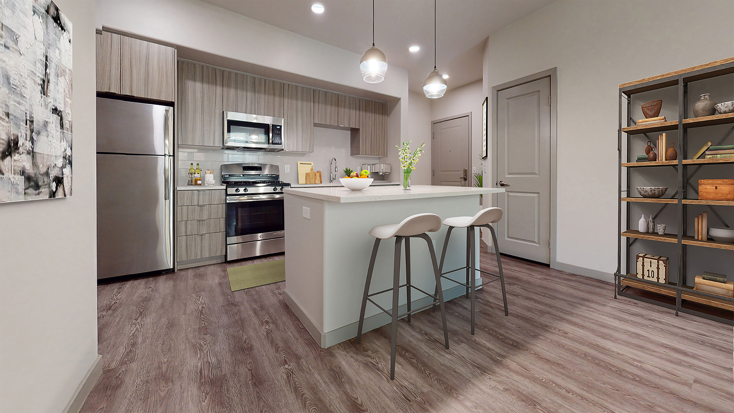 Open kitchen at AMLI Camarillo apartments with island seating, pendant lights, stainless steel appliances and modern wood cabinetry.