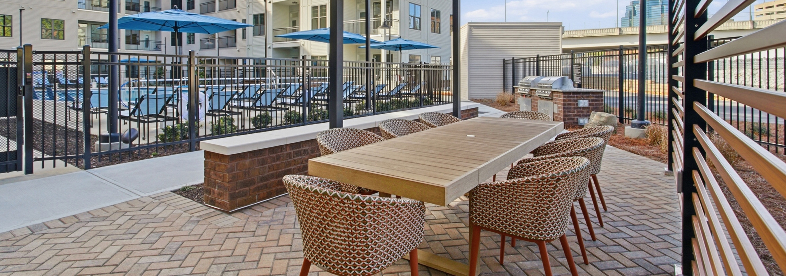 Outdoor kitchen with grill station overlooking the pool at AMLI Brookhaven.