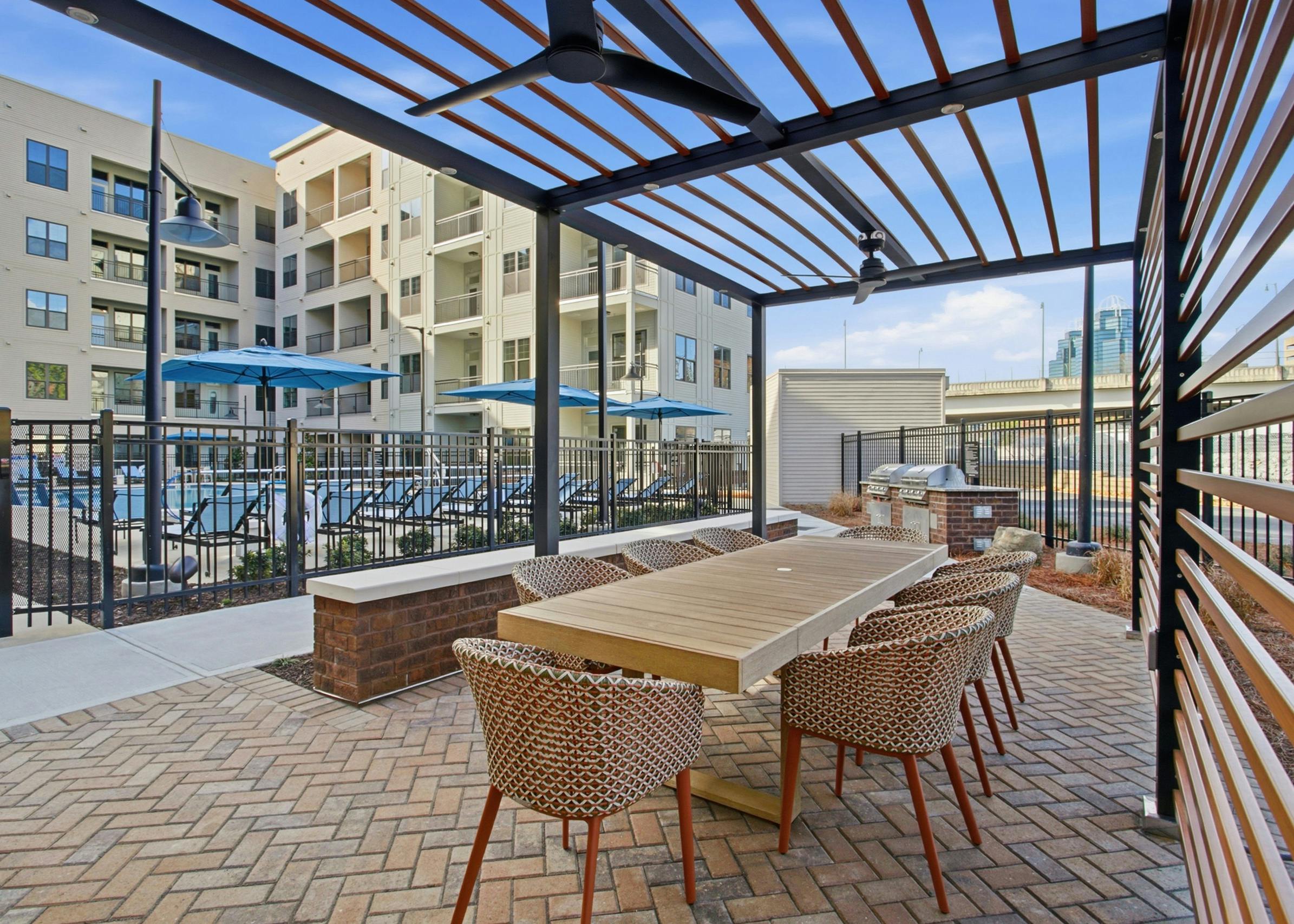 Outdoor kitchen with grill station overlooking the pool at AMLI Brookhaven.