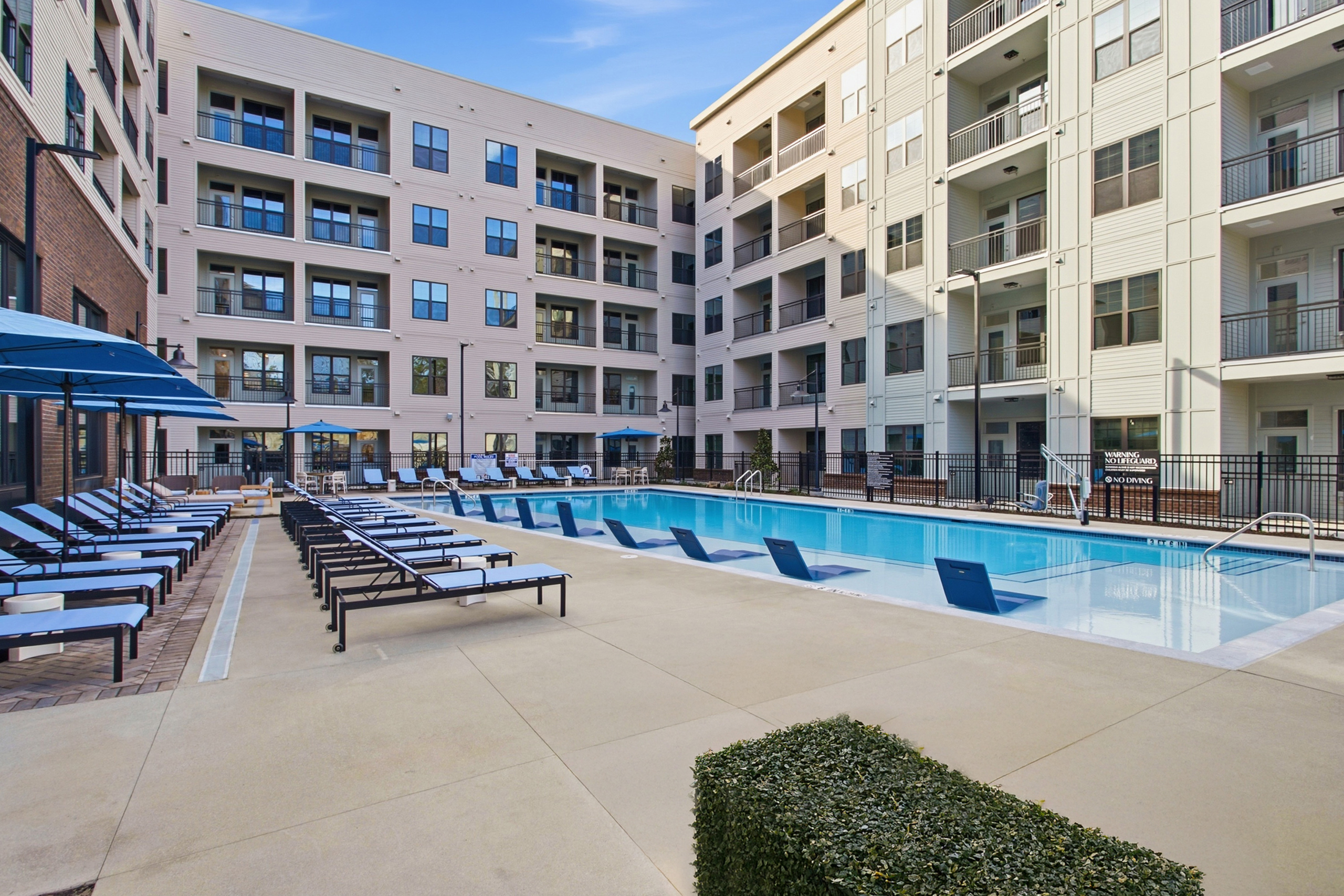 Apartment balconies facing swimming pool and lounge chairs at AMLI Brookhaven.