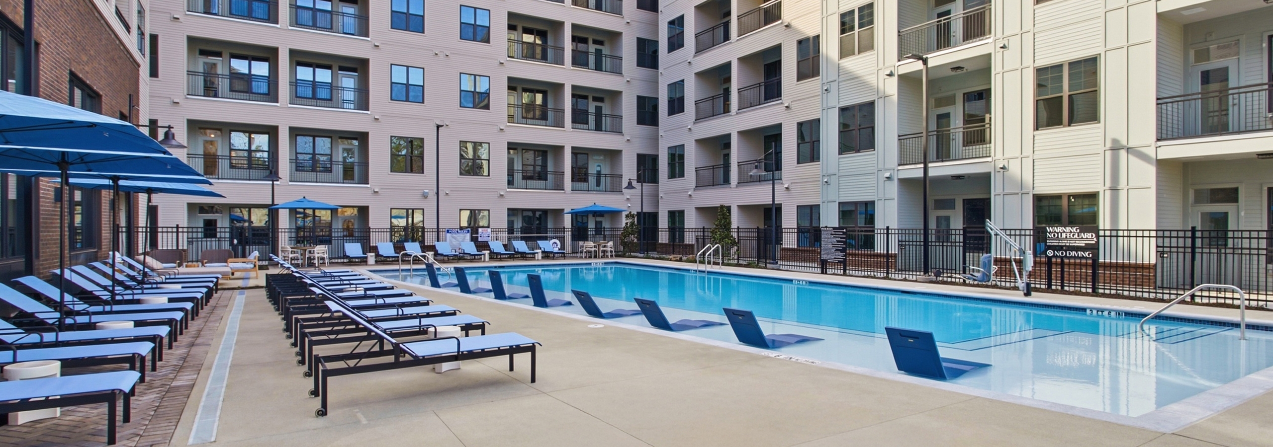 Apartment balconies facing swimming pool and lounge chairs at AMLI Brookhaven.