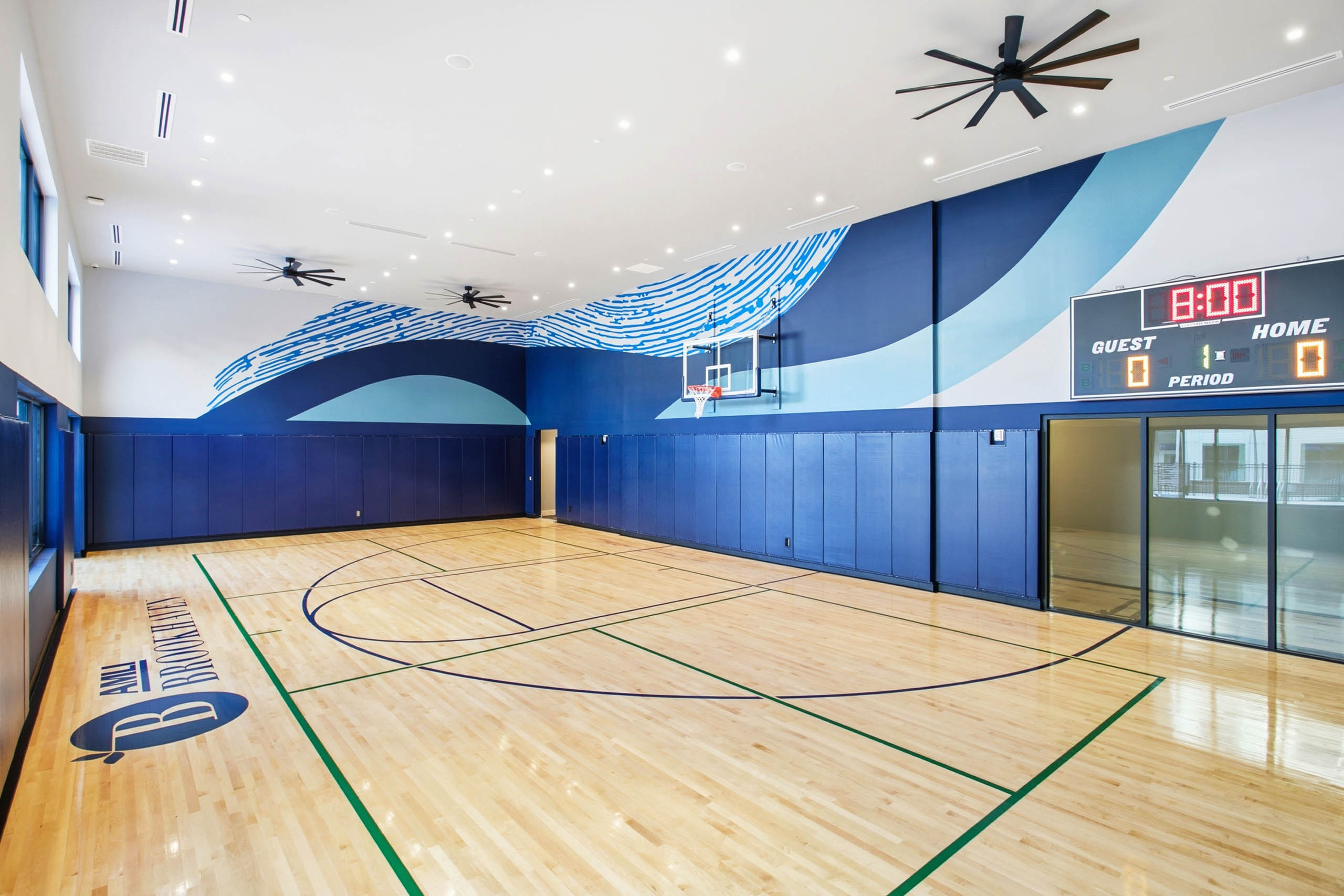 AMLI Brookhaven indoor sport court with a basketball hoop and electronic score board.