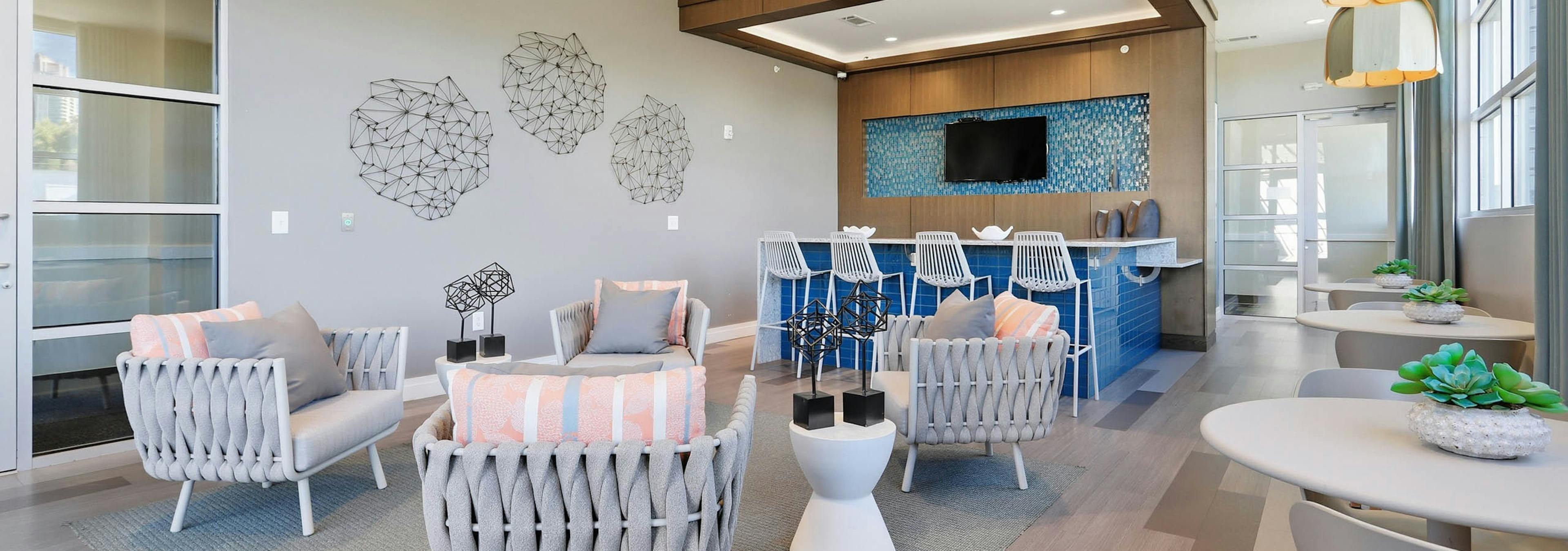 An interior view of a resident lounge at AMLI Buckhead with a large seating area and a flat screen television and wall art