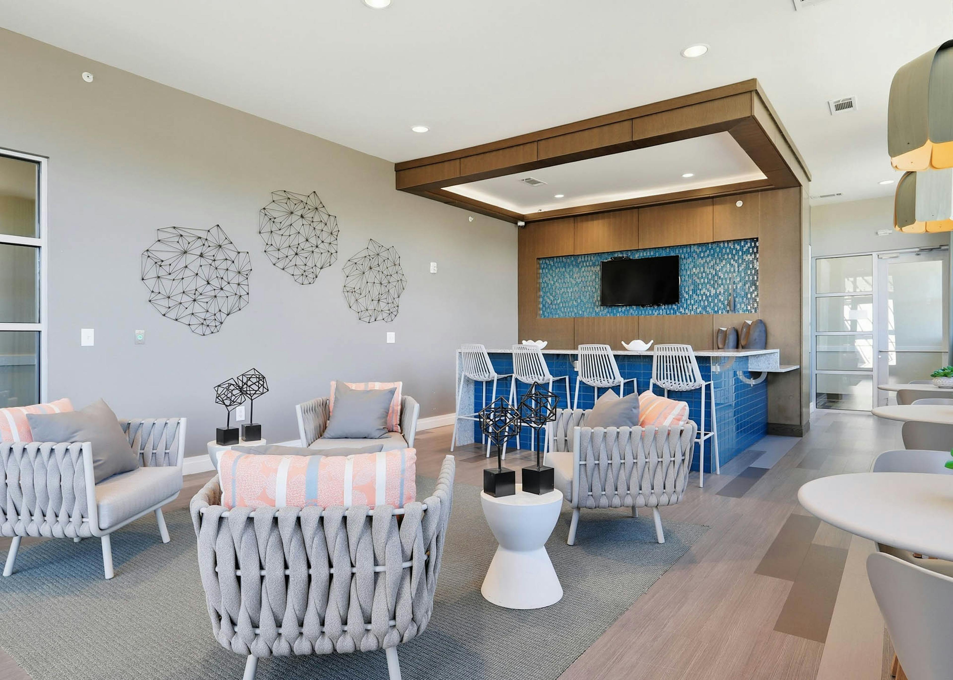 An interior view of a resident lounge at AMLI Buckhead with a large seating area and a flat screen television and wall art
