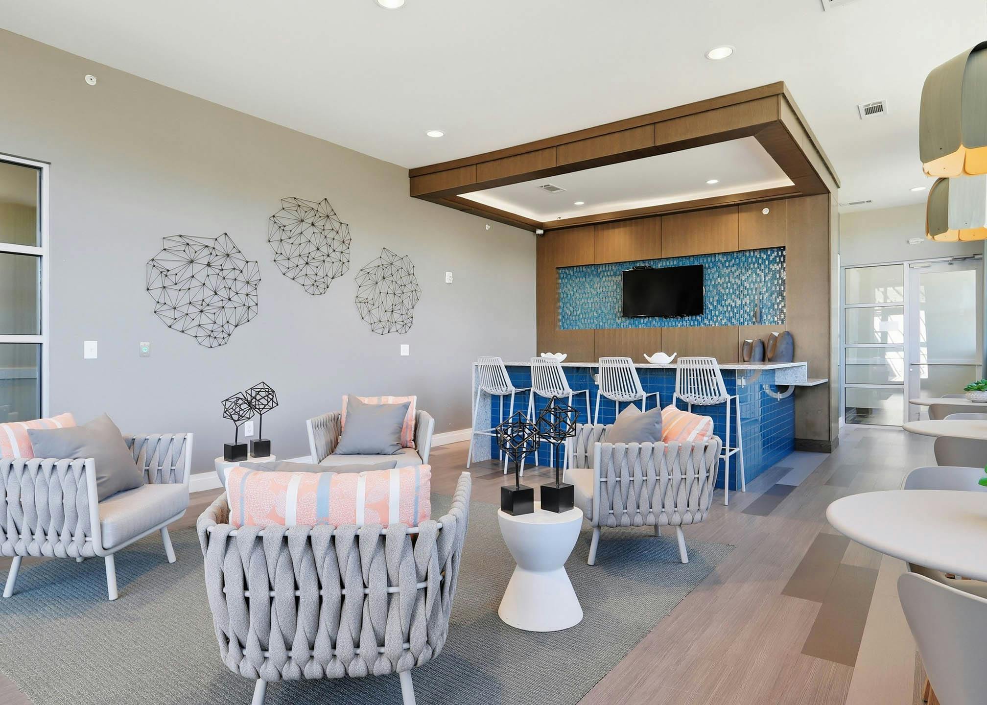 An interior view of a resident lounge at AMLI Buckhead with a large seating area and a flat screen television and wall art