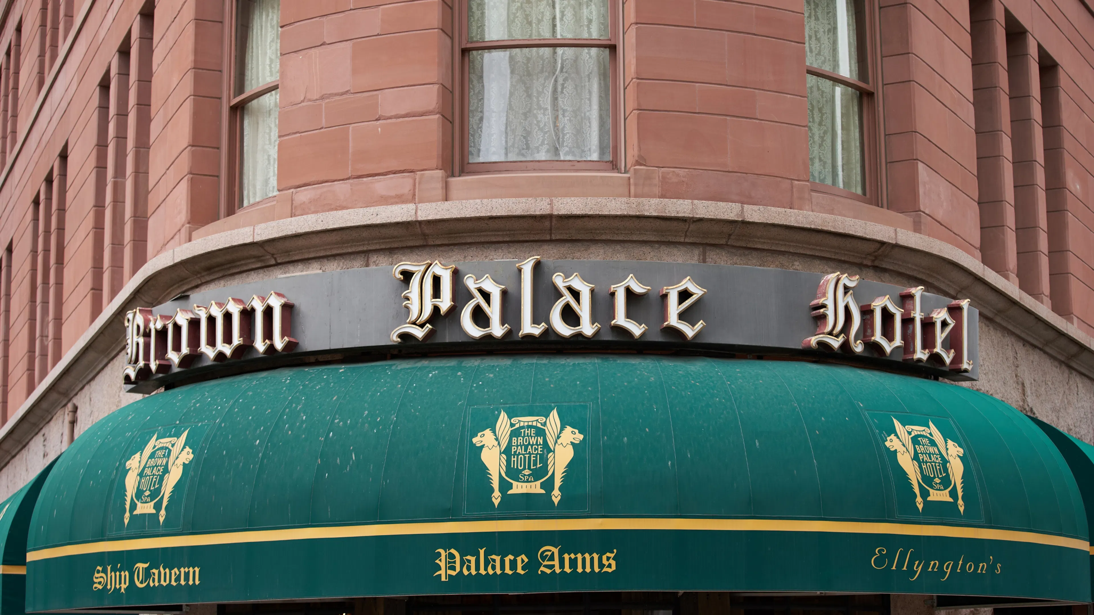 Exterior signage and green awnings of the historic Brown Palace Hotel in Denver, a landmark near the Golden Triangle submarket.
