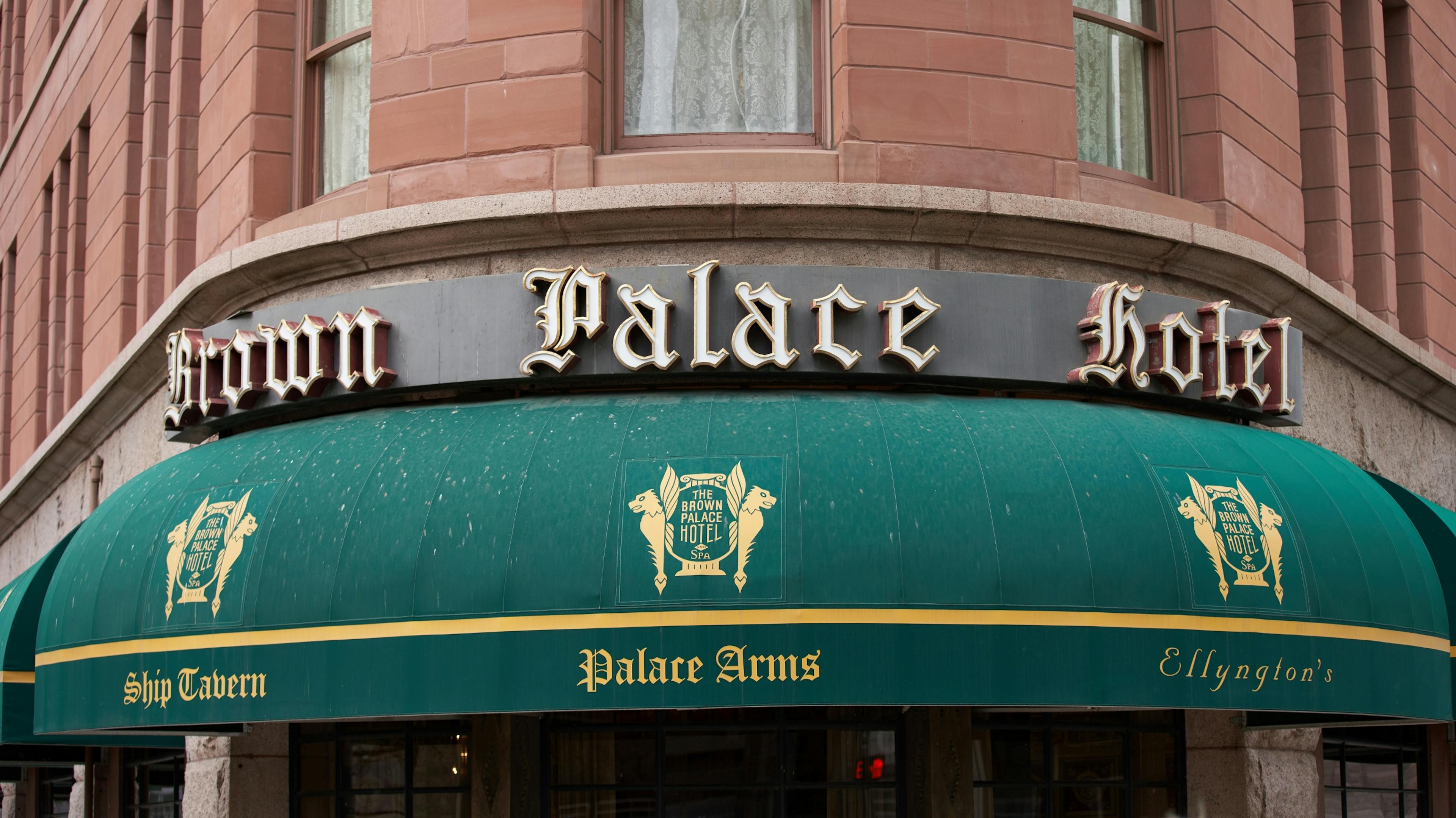 Exterior signage and green awnings of the historic Brown Palace Hotel in Denver, a landmark near the Golden Triangle submarket.