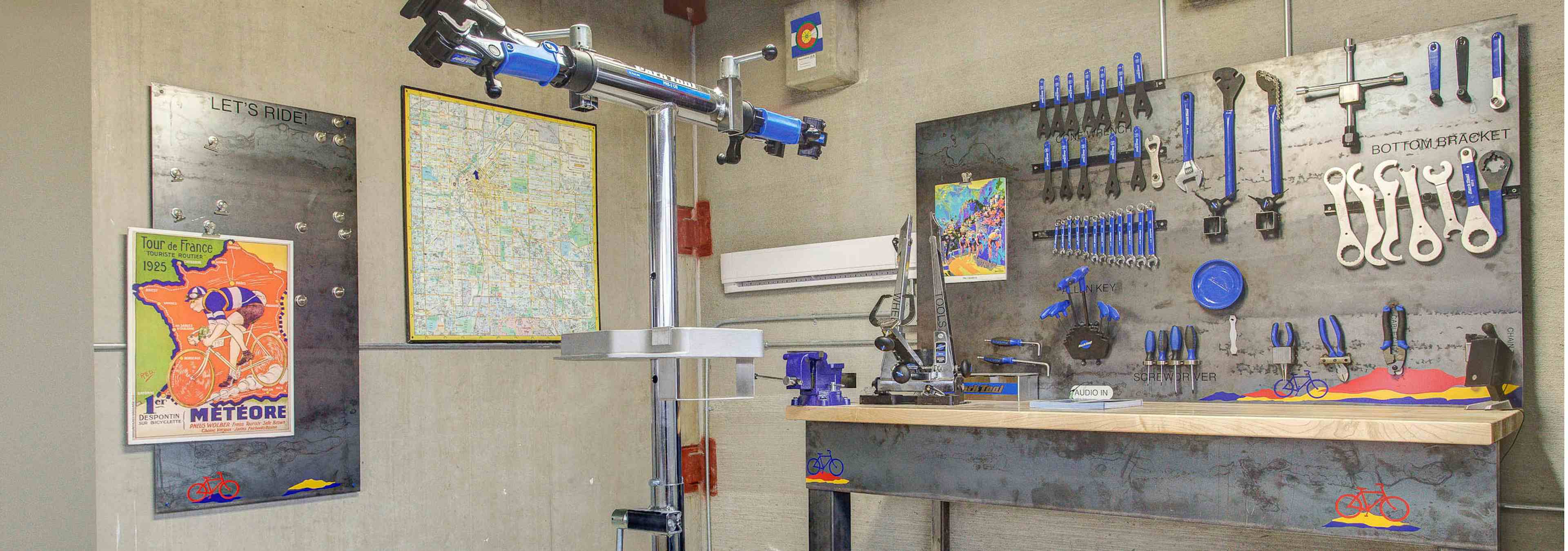 Interior of the bike repair room at AMLI Riverfront Park apartments with a work bench and tools and steel bike repair stand 