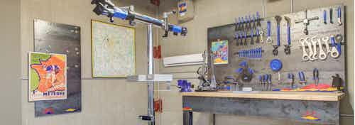 Interior of the bike repair room at AMLI Riverfront Park apartments with a work bench and tools and steel bike repair stand