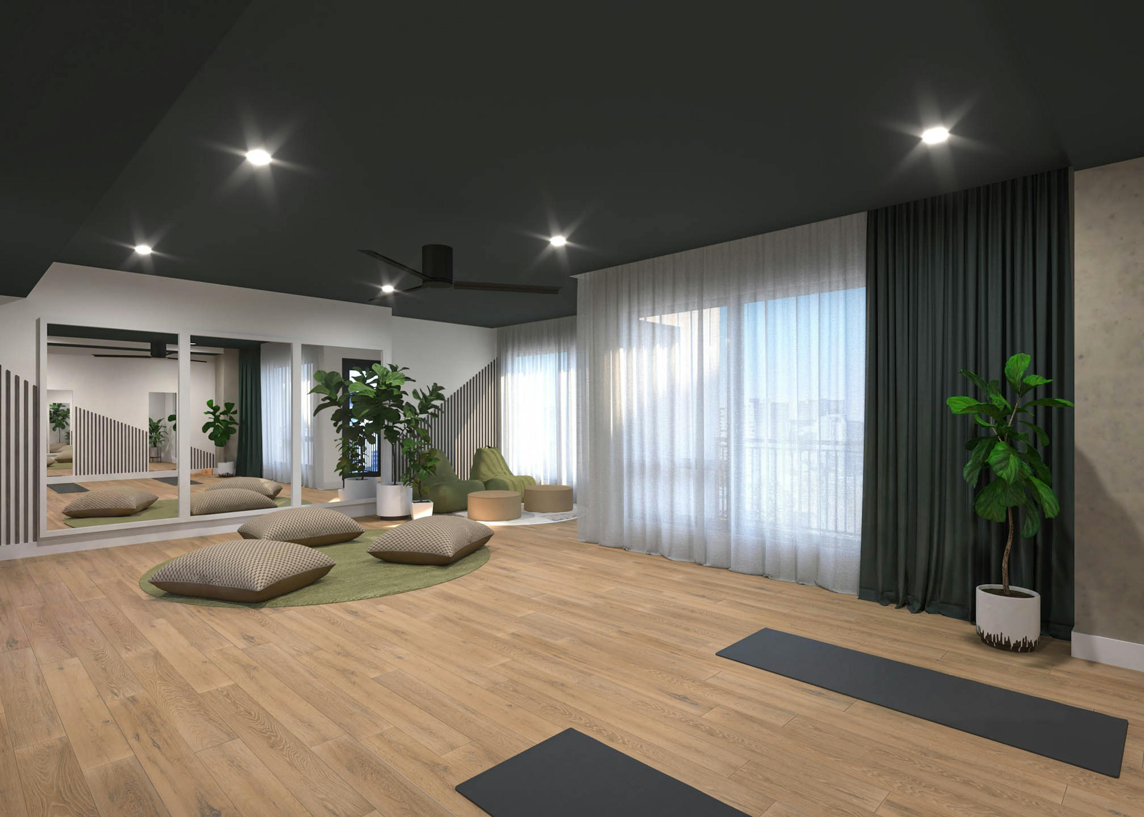 Interior view of yoga studio amenity with fitness equipment and cushions with mirrors at AMLI Golden Triangle.