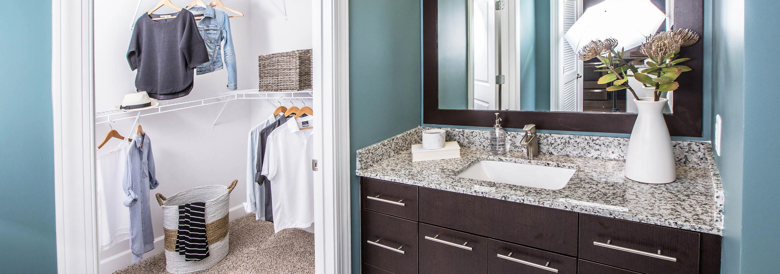 Interior view of a bathroom at AMLI Joya apartment with double sink vanity, large mirror on wall and granite counters