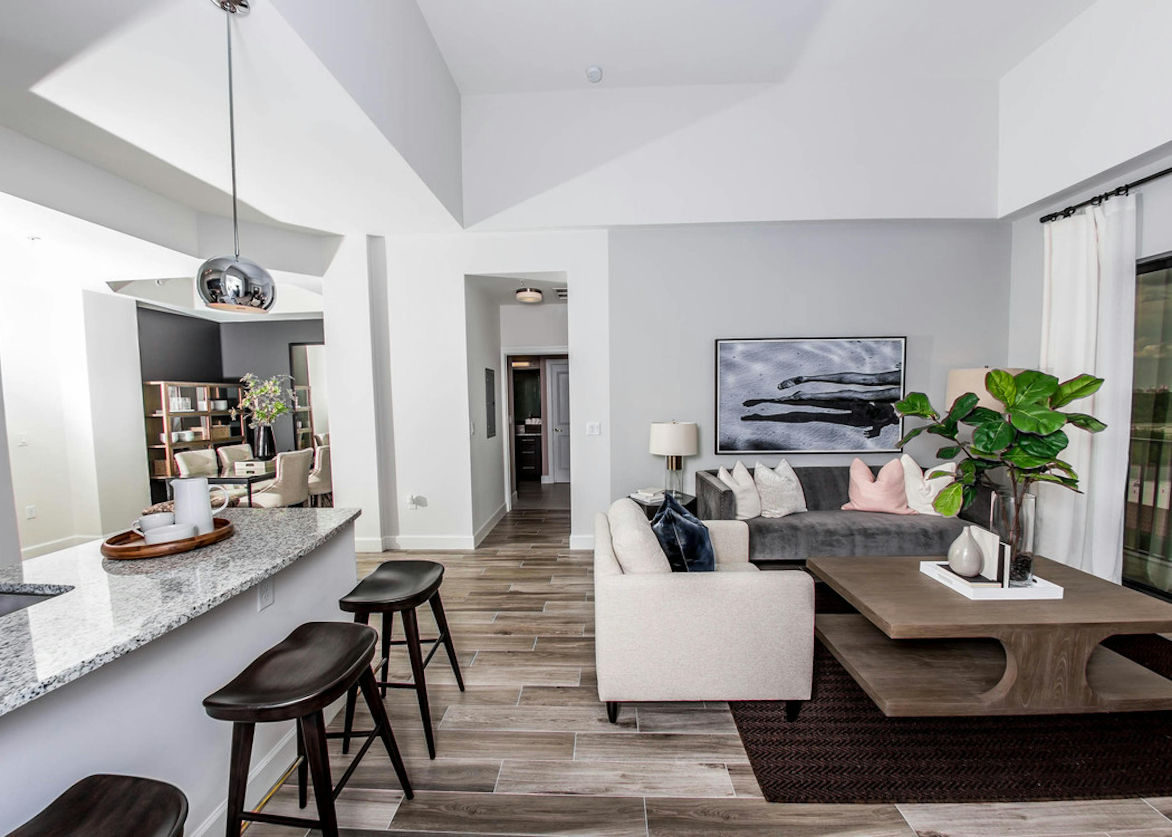  An AMLI Joya apartment contemporary living area and kitchen with stainless steel appliances and dark cabinetry