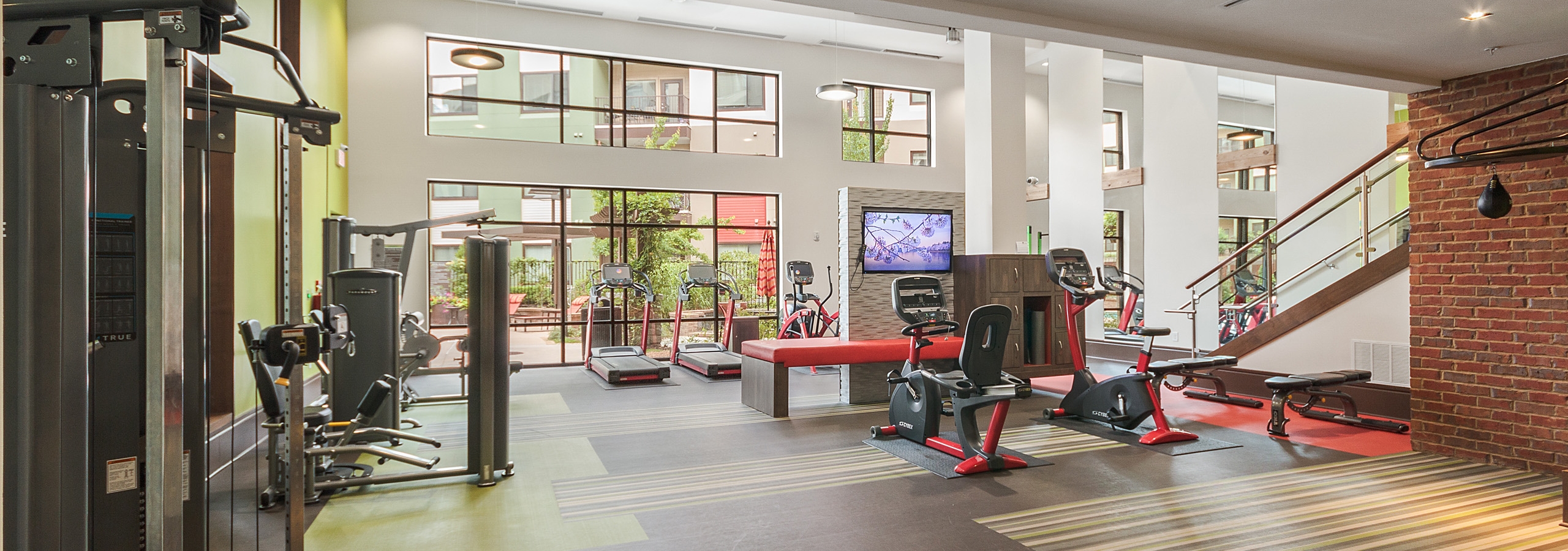 Interior of the fitness center at AMLI Ponce Park apartments with multiple treadmills and exercise bike and weight machines
