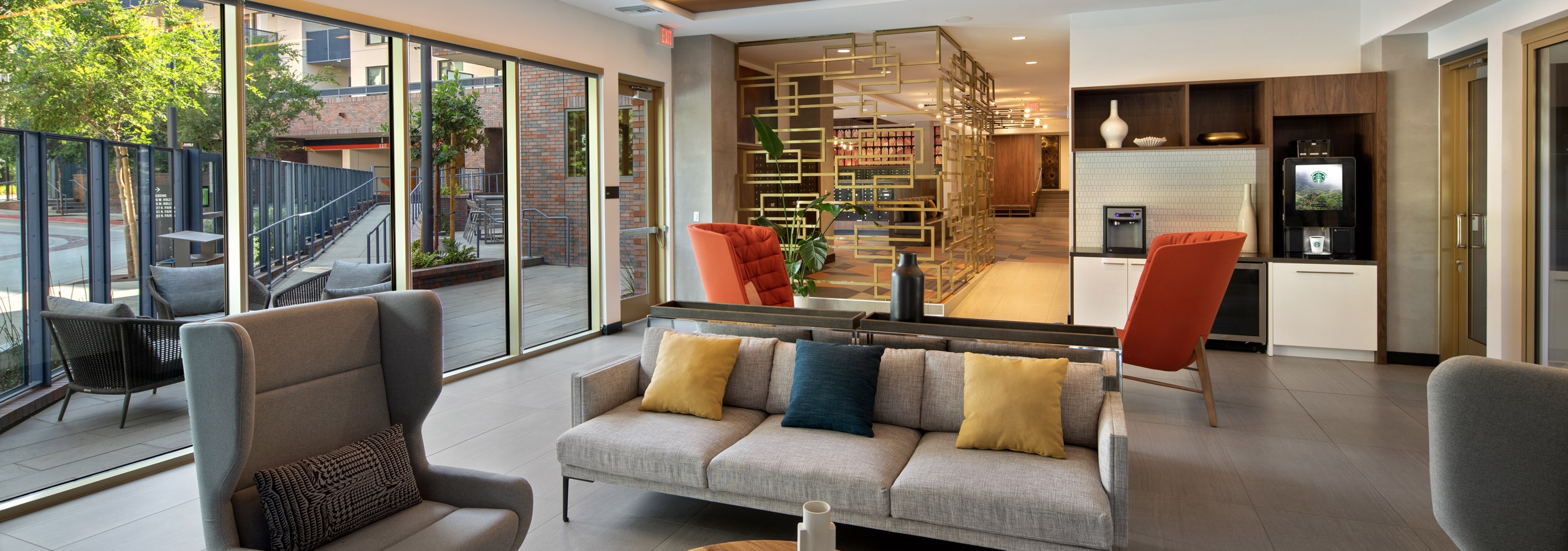 Interior view of java bar lounge and various stylish seating with colorful pillows and big windows at AMLI Old Pasadena