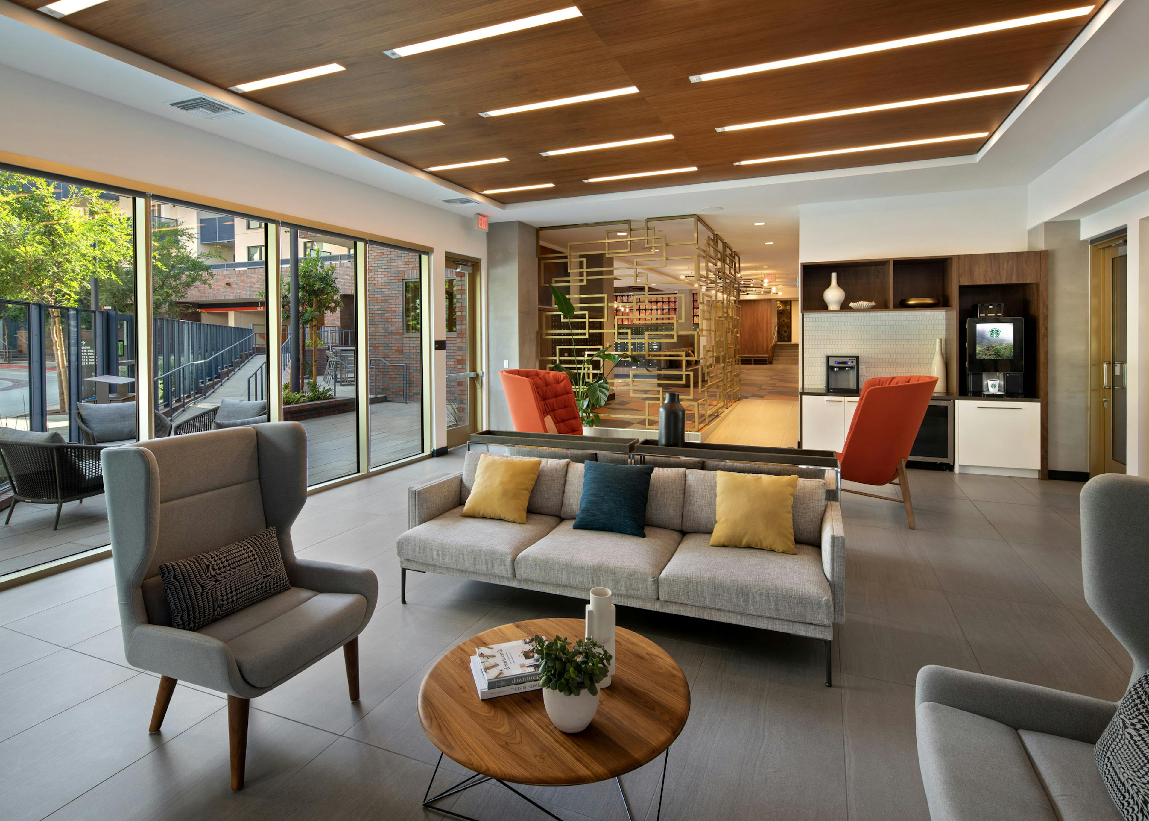 Interior view of java bar lounge and various stylish seating with colorful pillows and big windows at AMLI Old Pasadena