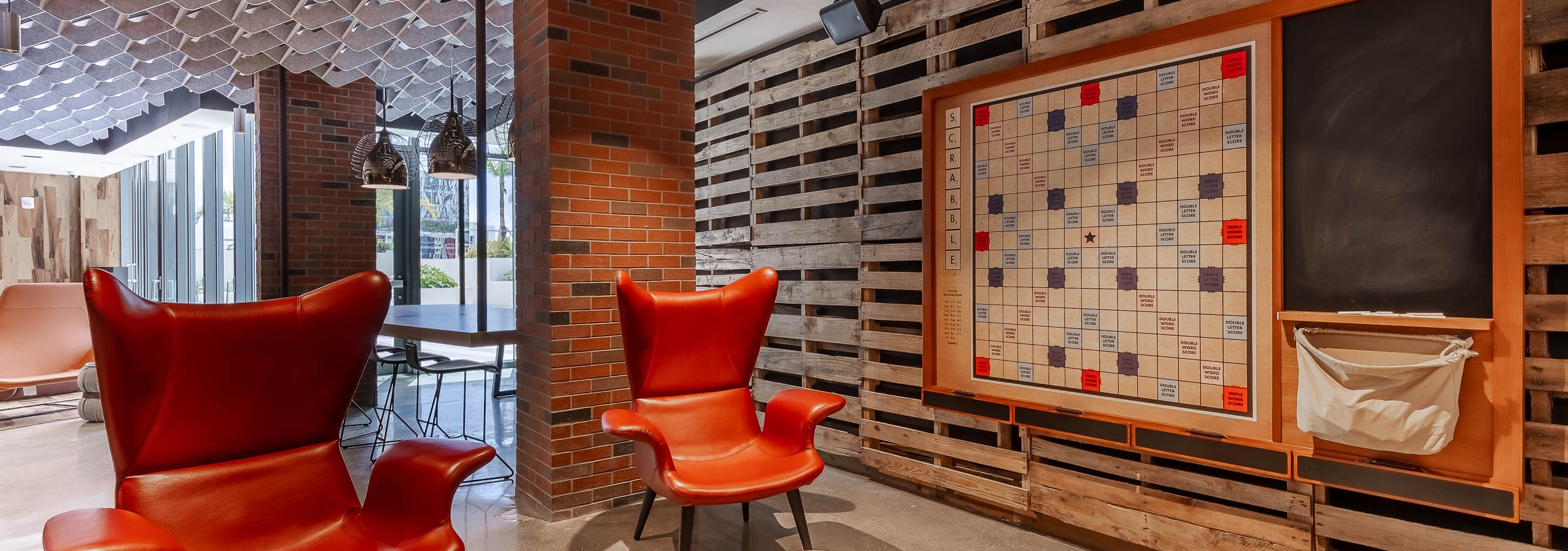 Interior view of an amenity space at AMLI Midtown Miami apartments with yellow seating area, coffee table, black and white tiles