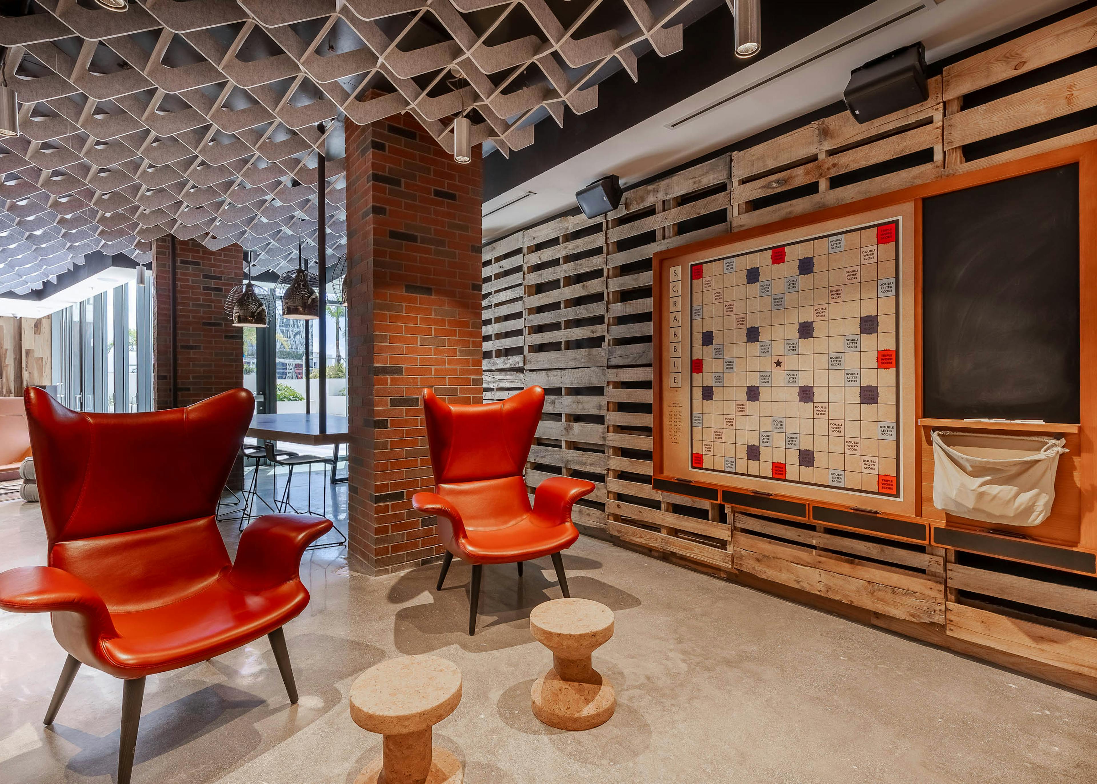 Interior view of an amenity space at AMLI Midtown Miami apartments with yellow seating area, coffee table, black and white tiles 