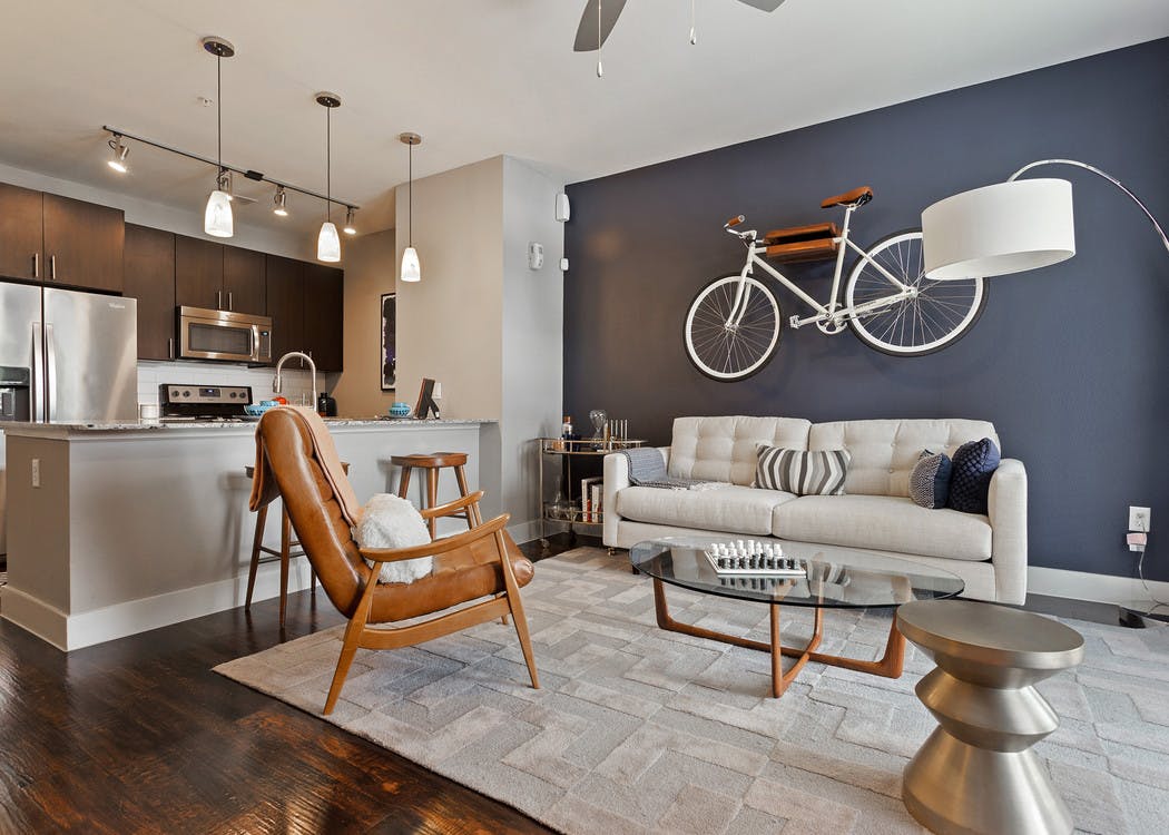 Interior view of AMLI Covered Bridge living area with a blue accent wall and pendant lighting in the kitchen