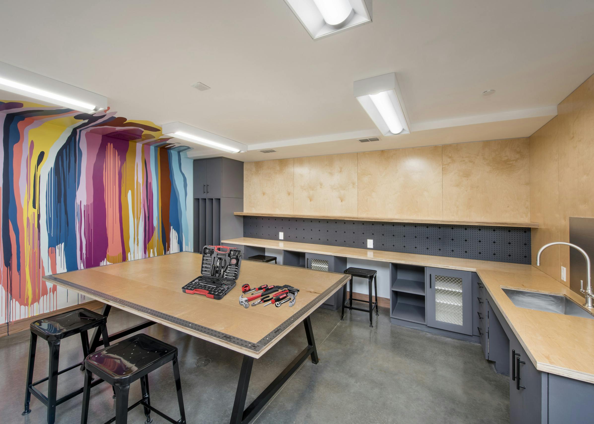 DIY maker space at AMLI Lenox with colorful painted wall and tools and sink as well as work areas for residents to create